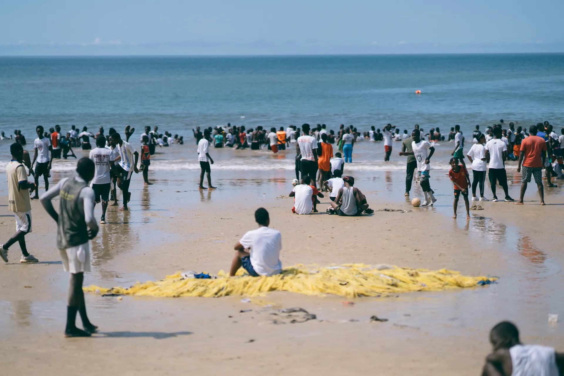 Crowd of people enjoying a sunny day at the beach.
