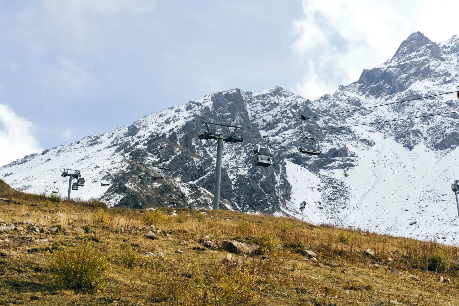 a ski lift going up the side of a snow covered mountain