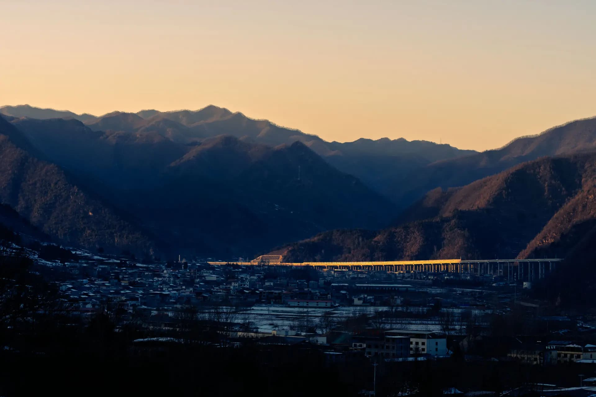 Mountains and valley illuminated by sunset light