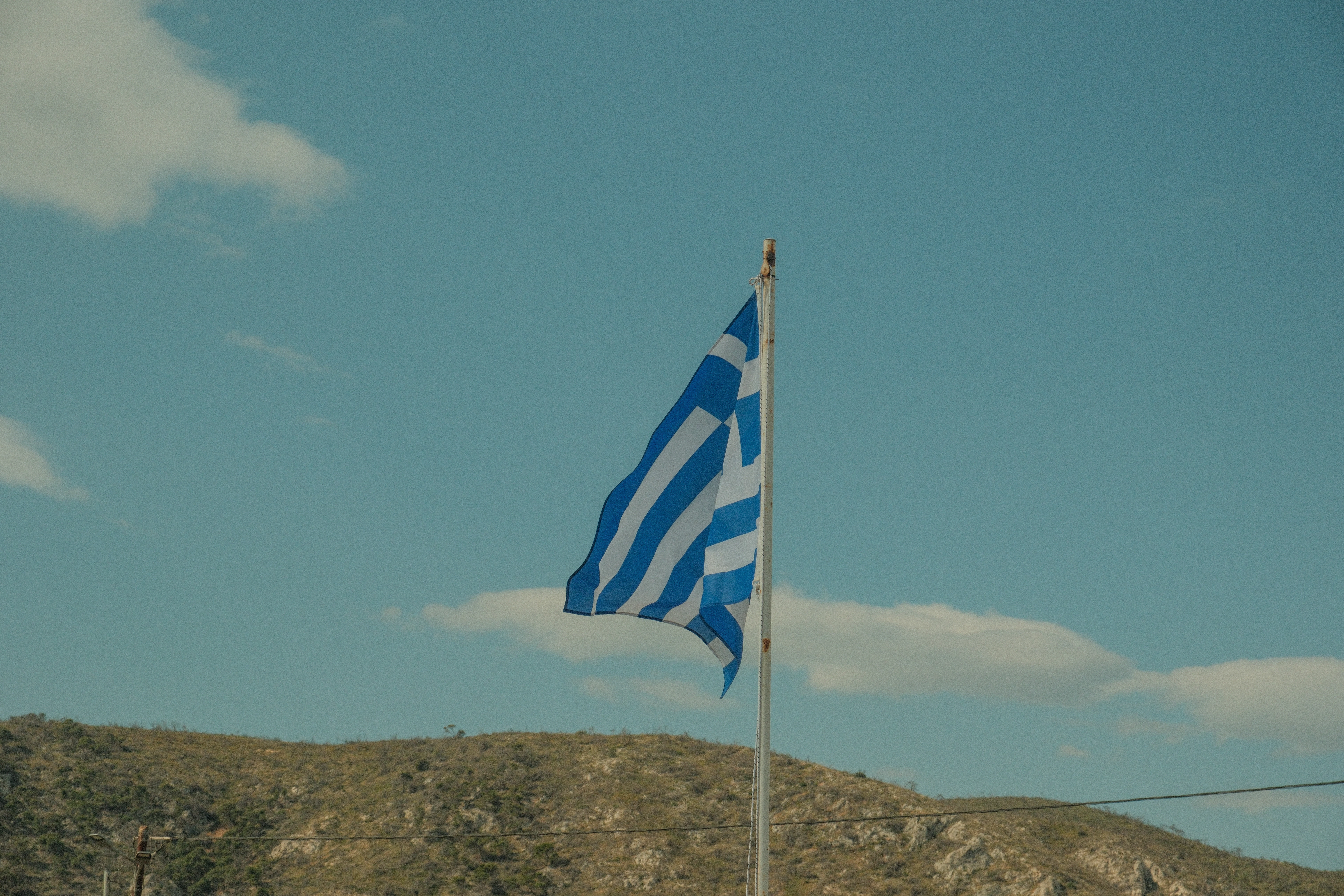 a blue and white flag flying in the wind
