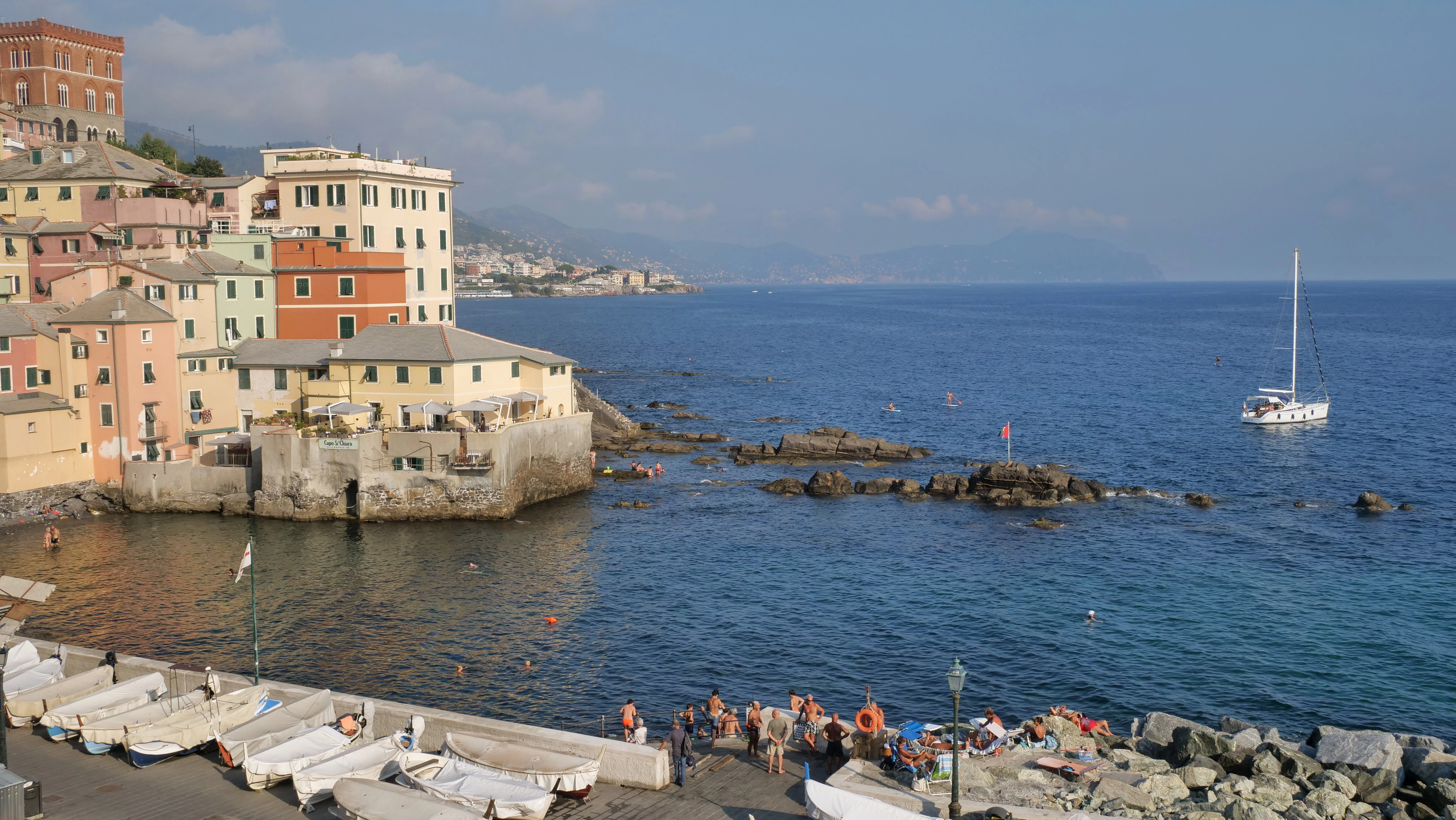 a group of people standing on a pier next to a body of water