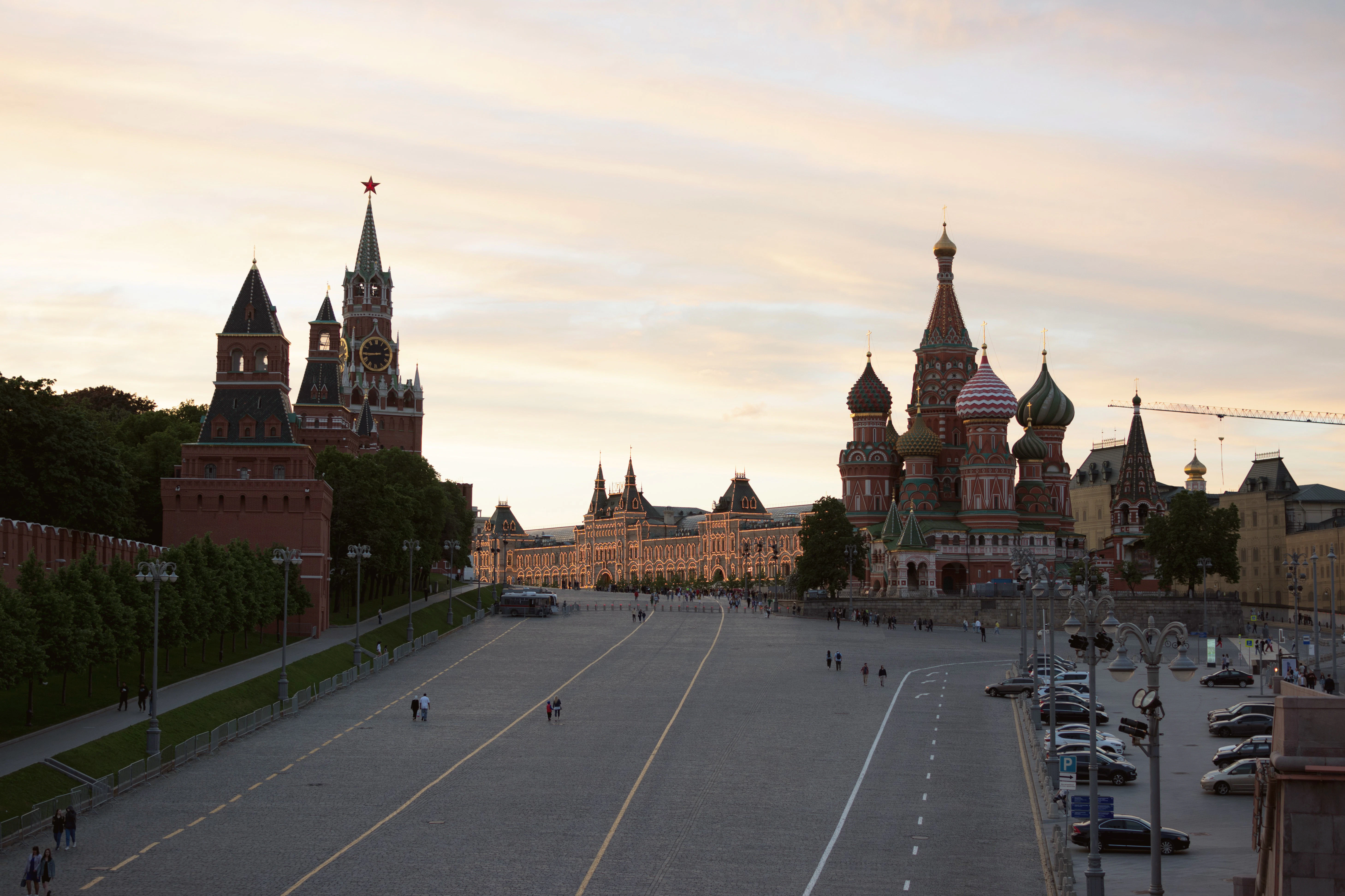 a road with cars and buildings along it with Red Square in the background