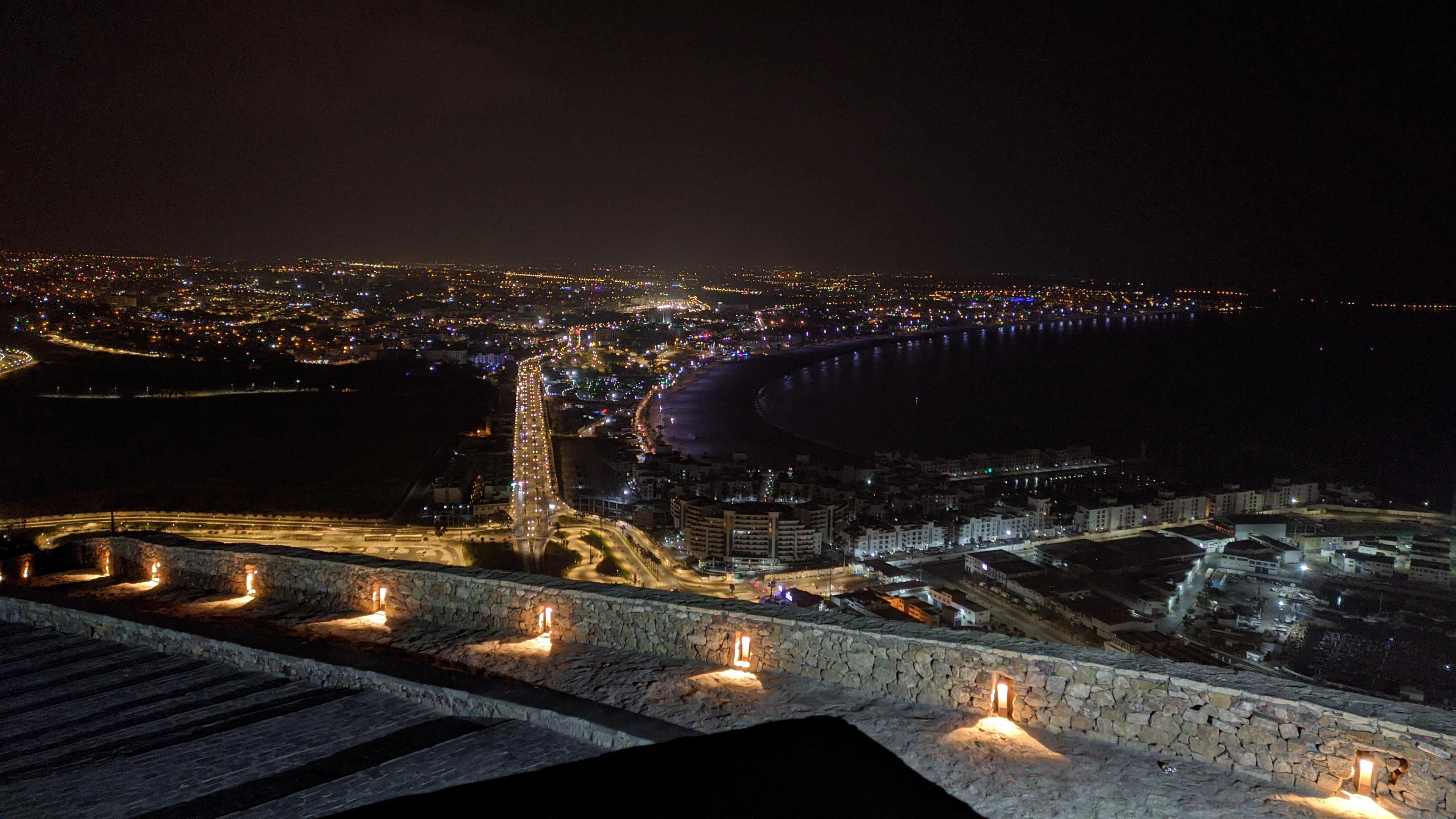 City lights illuminate a bay at night.