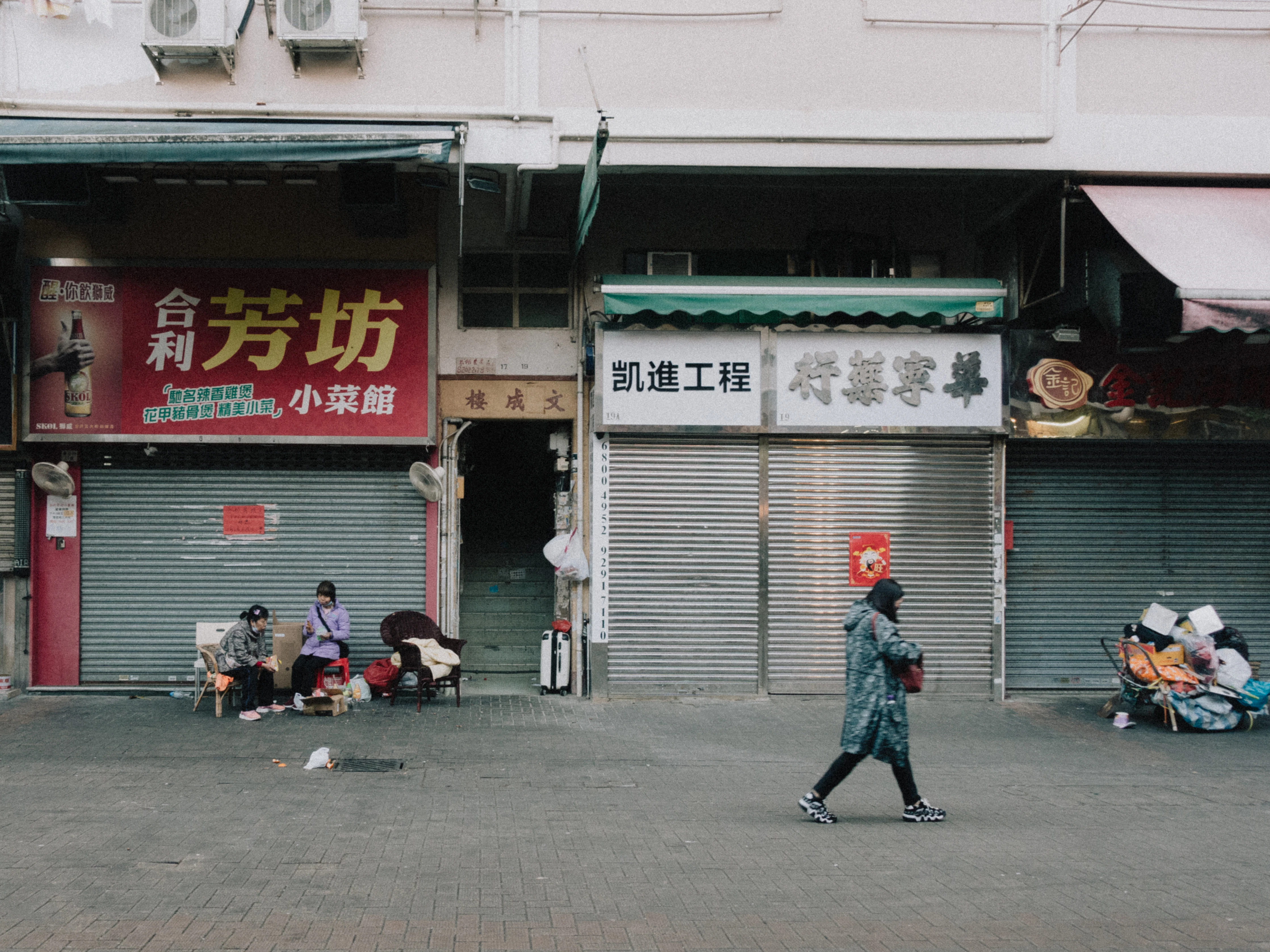 a person walking down a street in front of a store