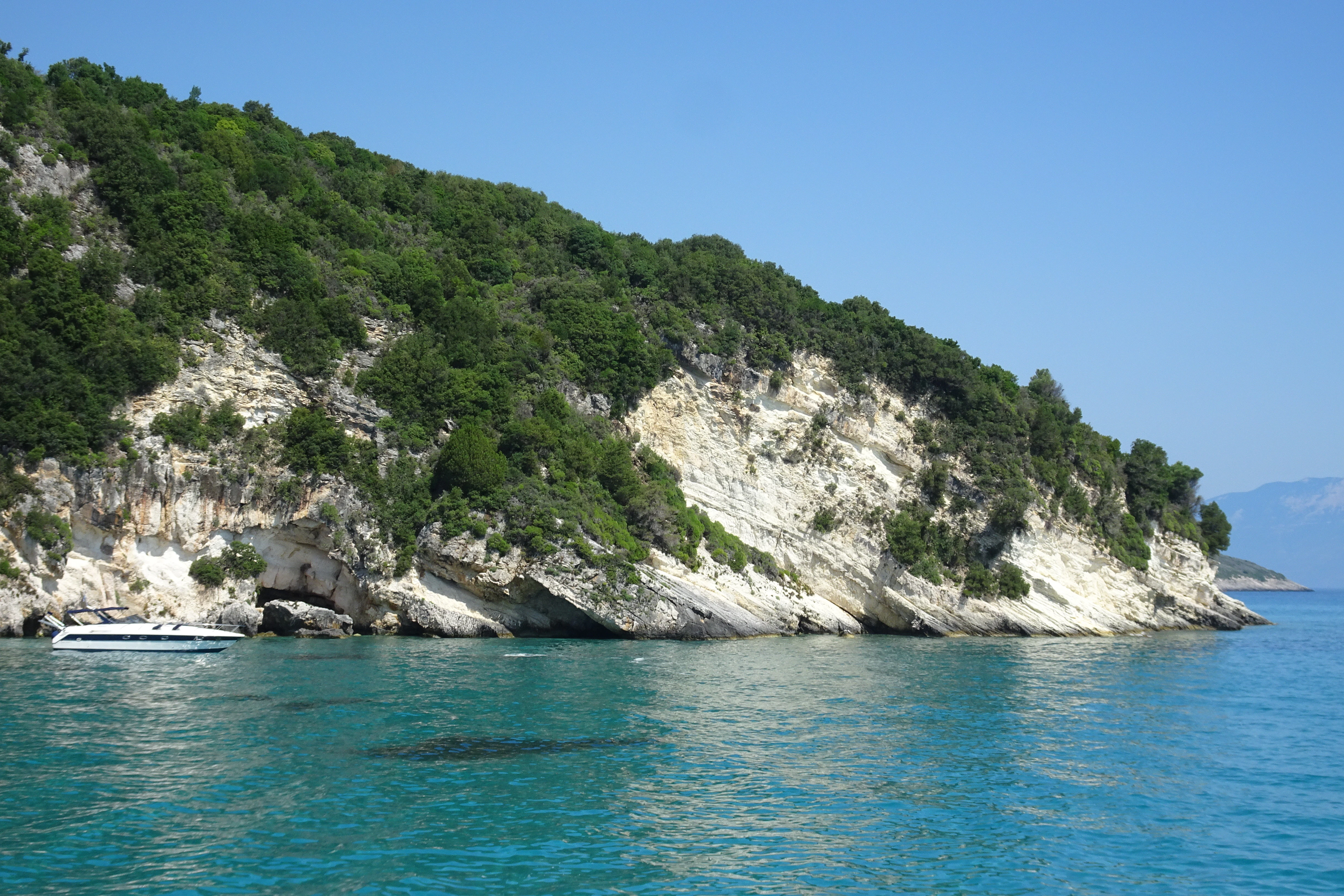 a boat in a body of water near a mountain