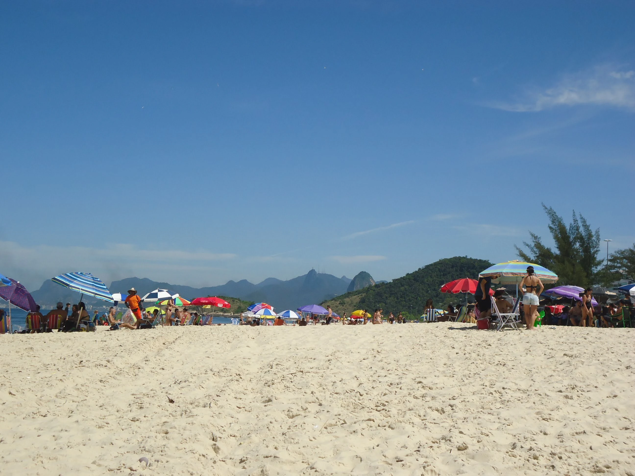 a group of people standing on top of a sandy beach