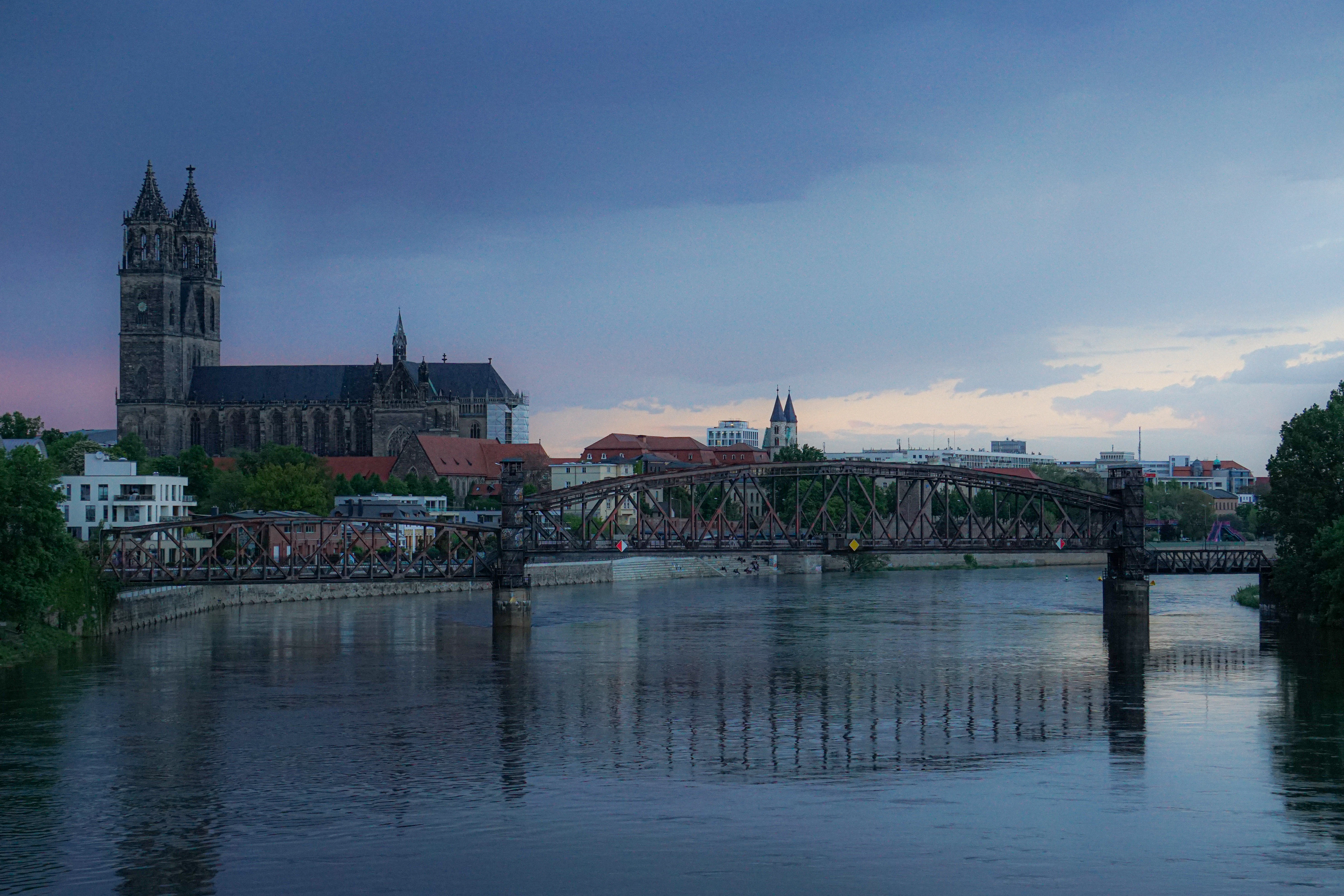 body of water near bridge and buildings during daytime