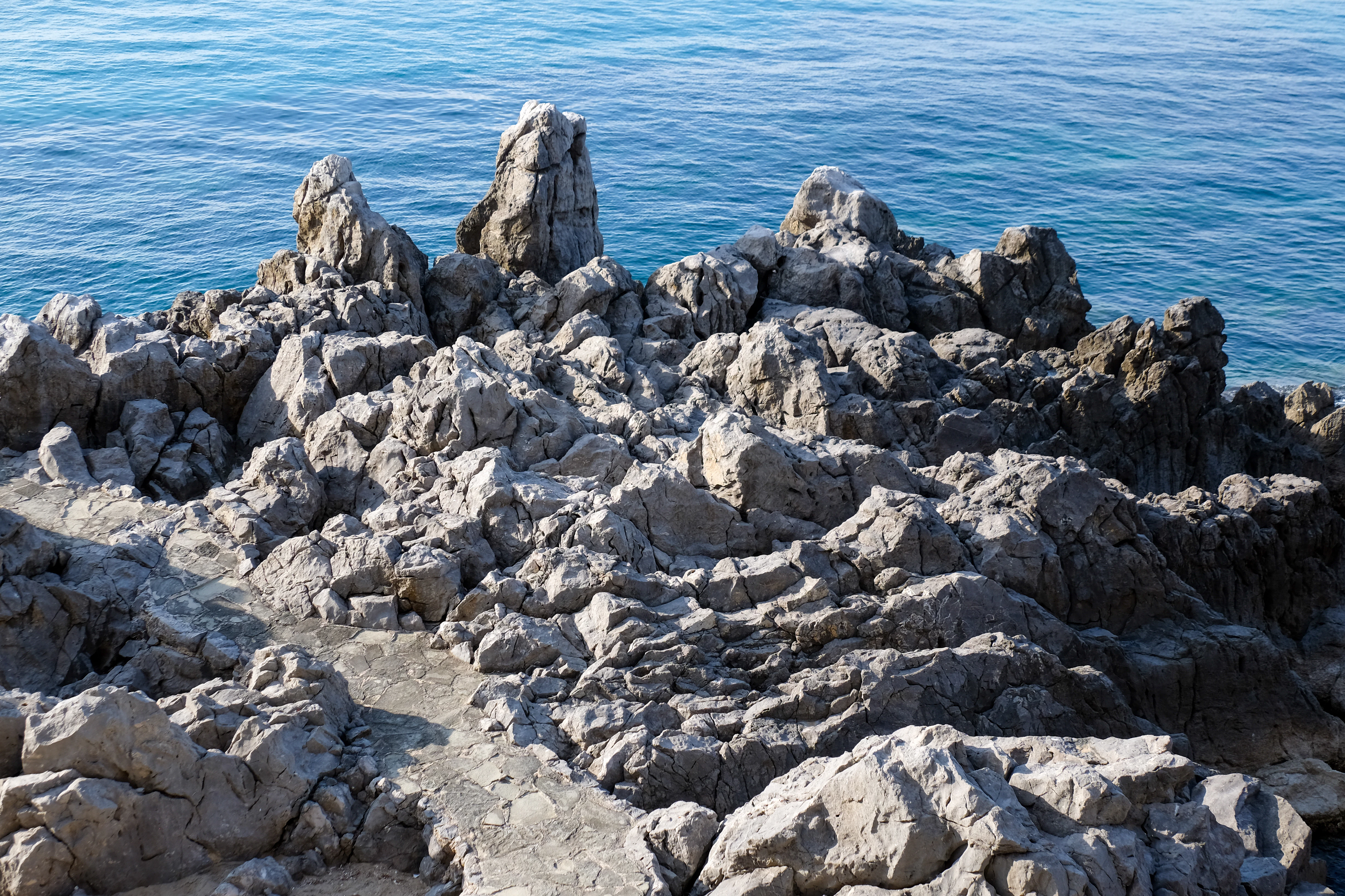 a rocky beach with a body of water in the background