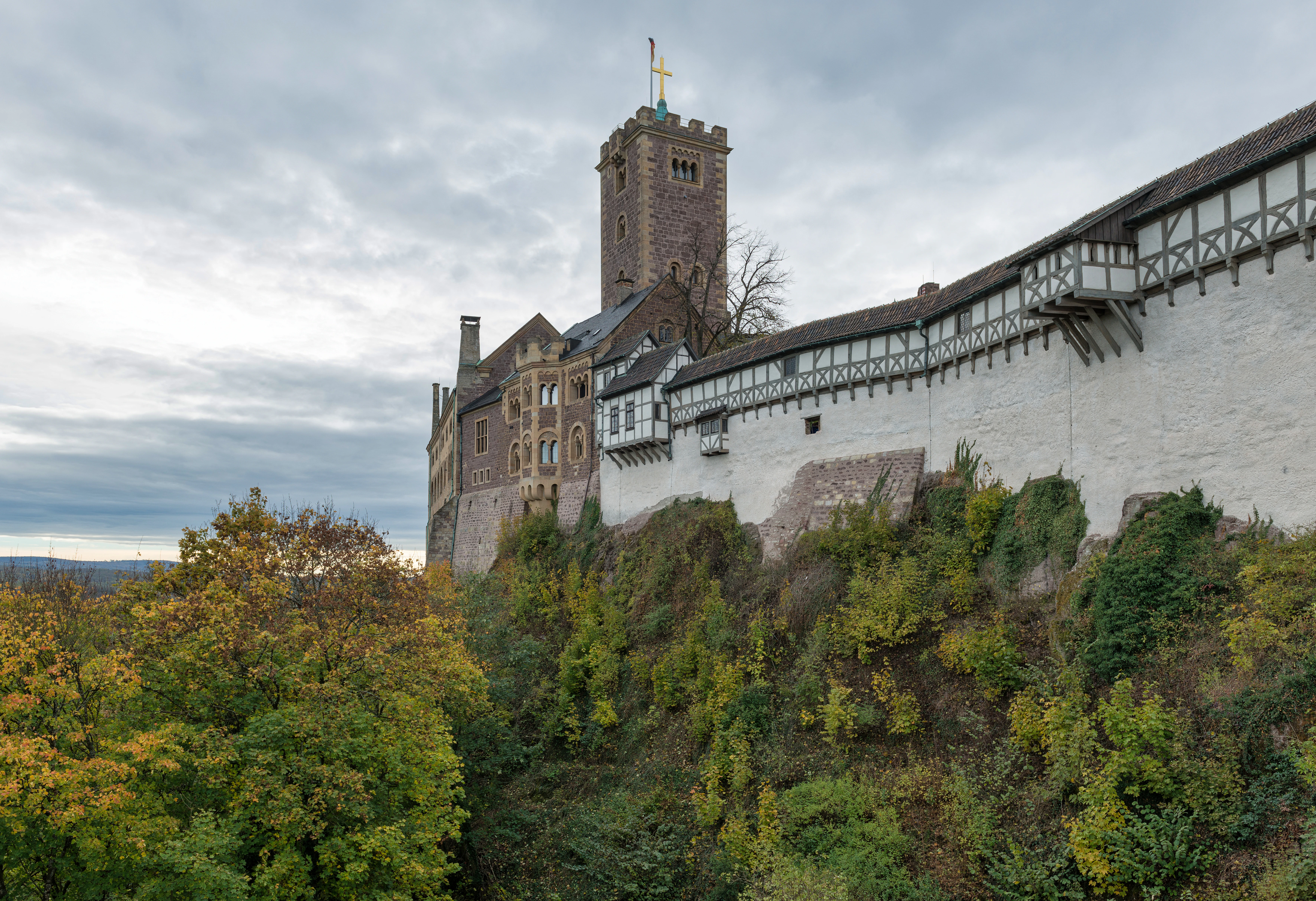 A large castle perched on a hill with trees.