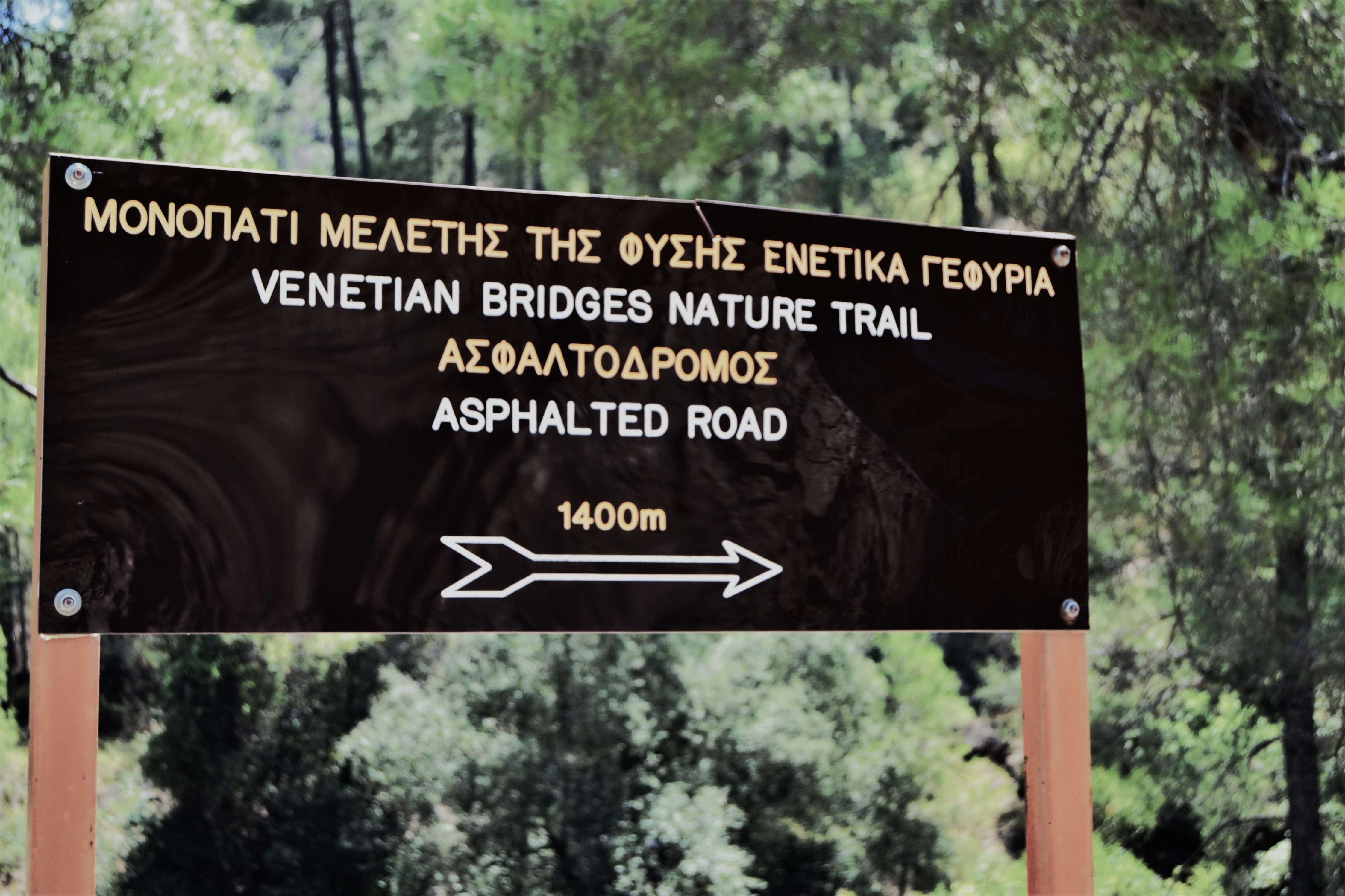 A sign in the middle of a wooded area