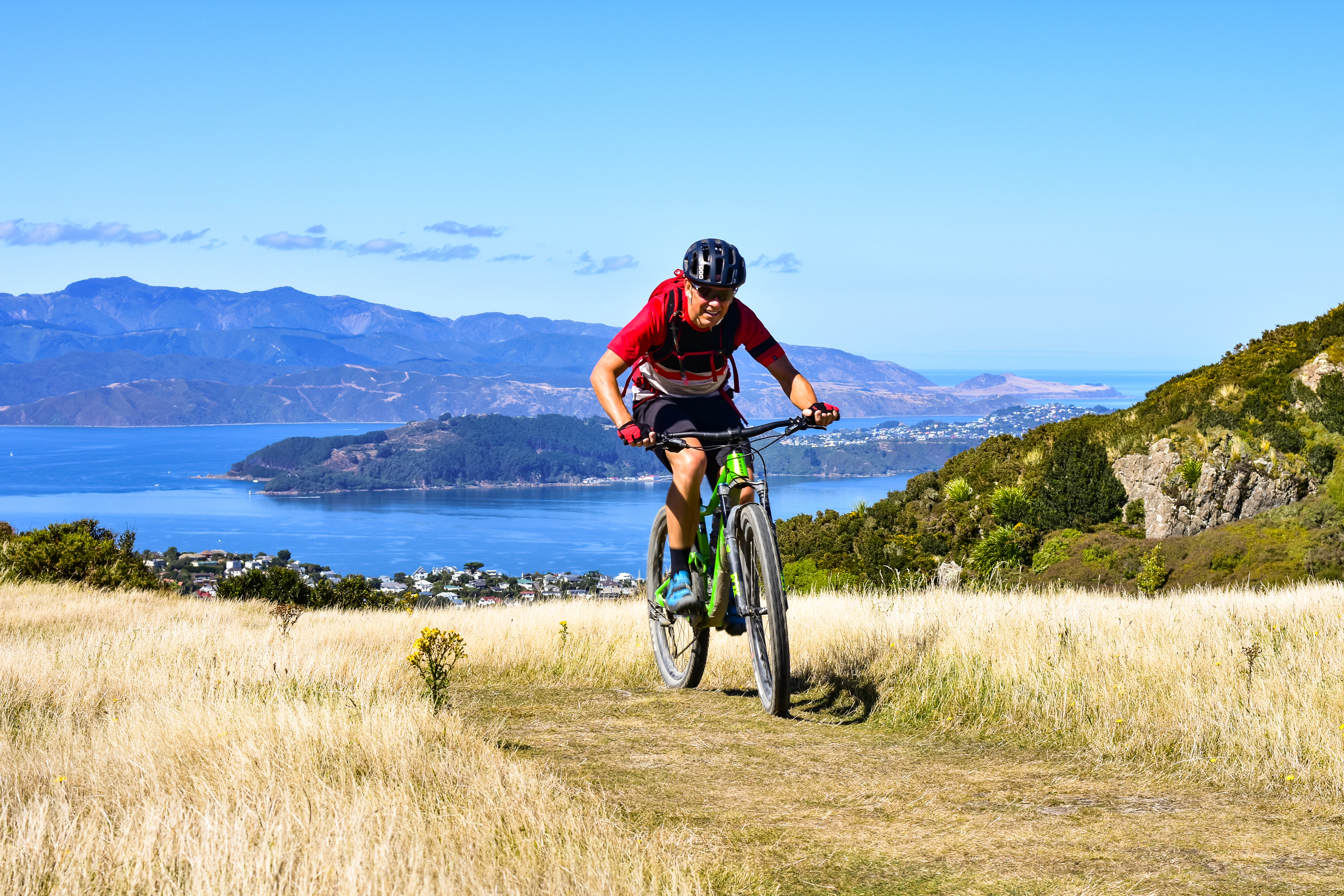 A person riding a mountain bike on a grassy trail.