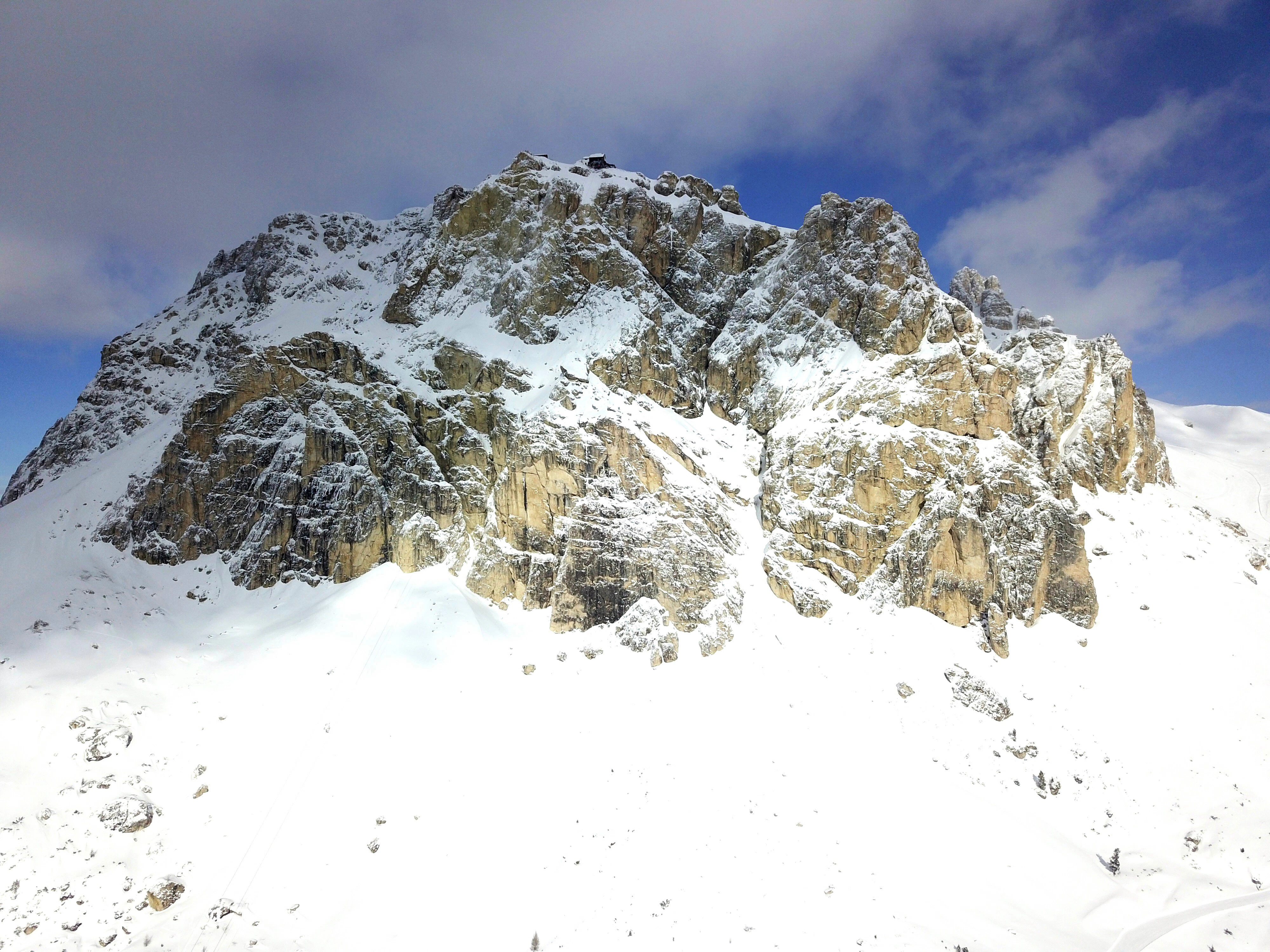 a large mountain covered in snow under a blue sky