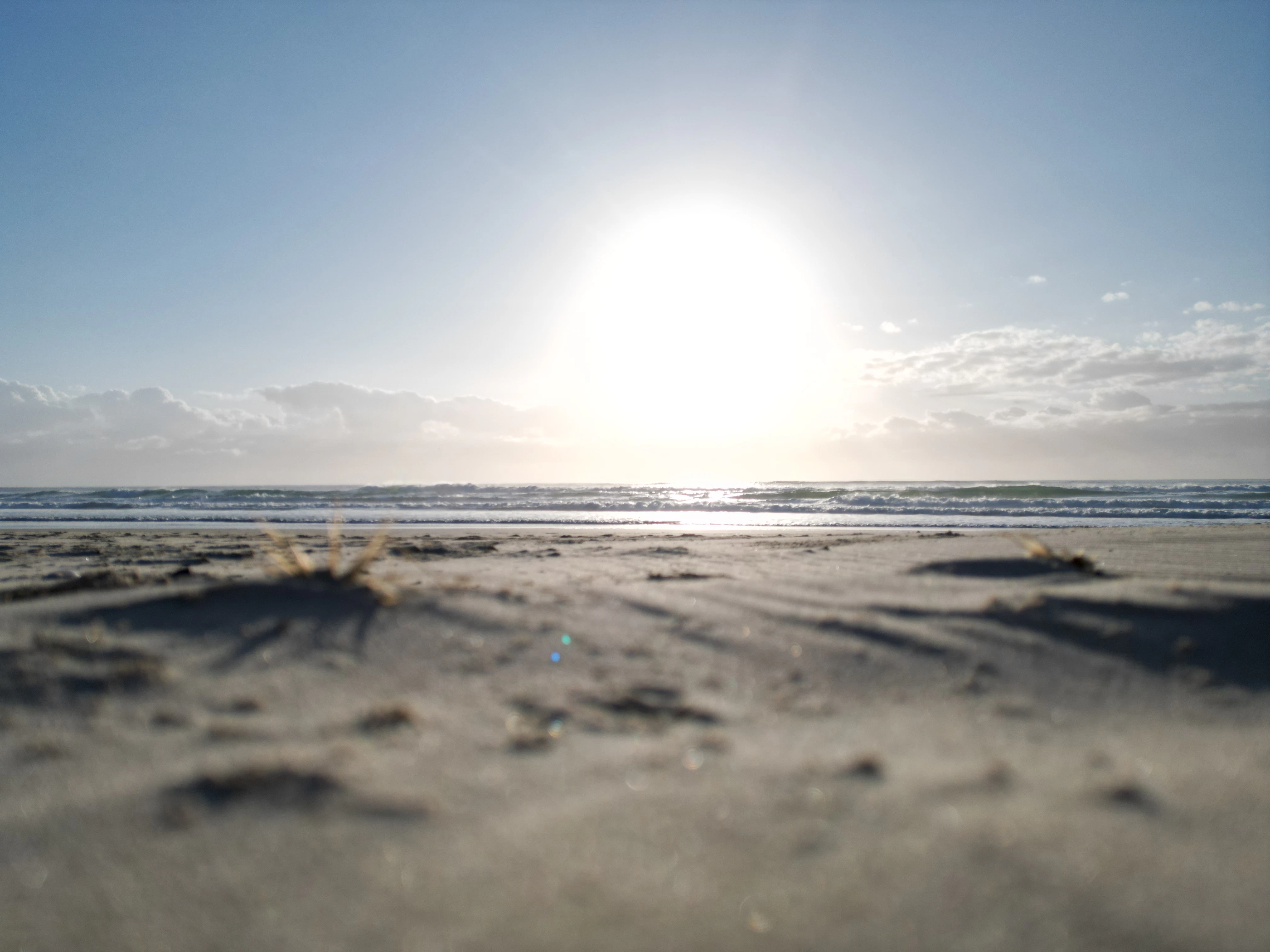 Bright sun over a sandy beach and ocean