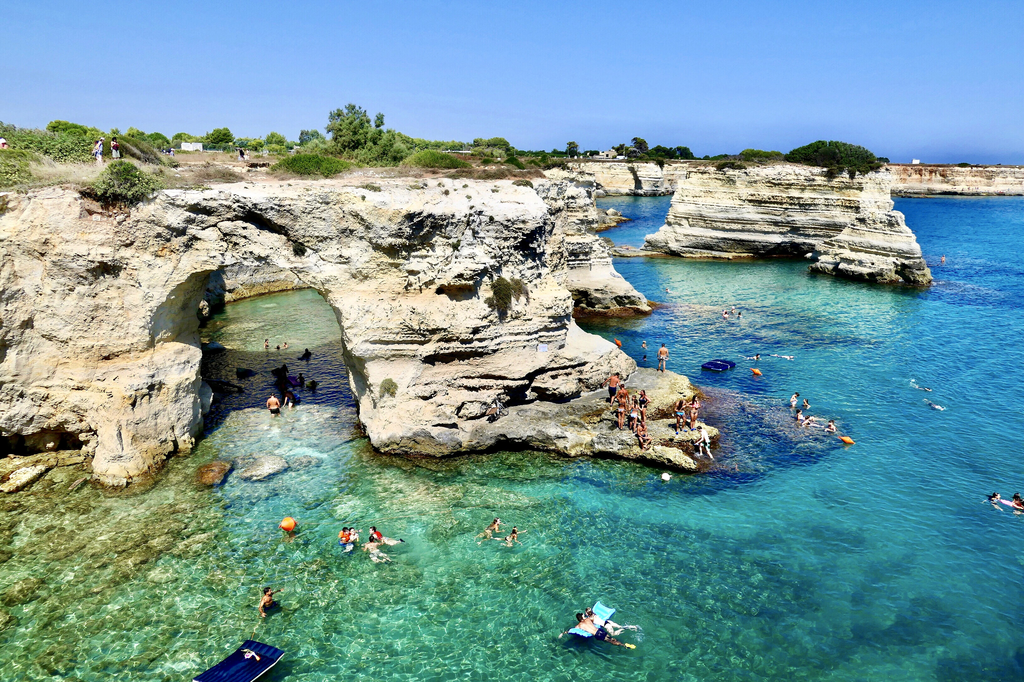 people swimming on sea during daytime