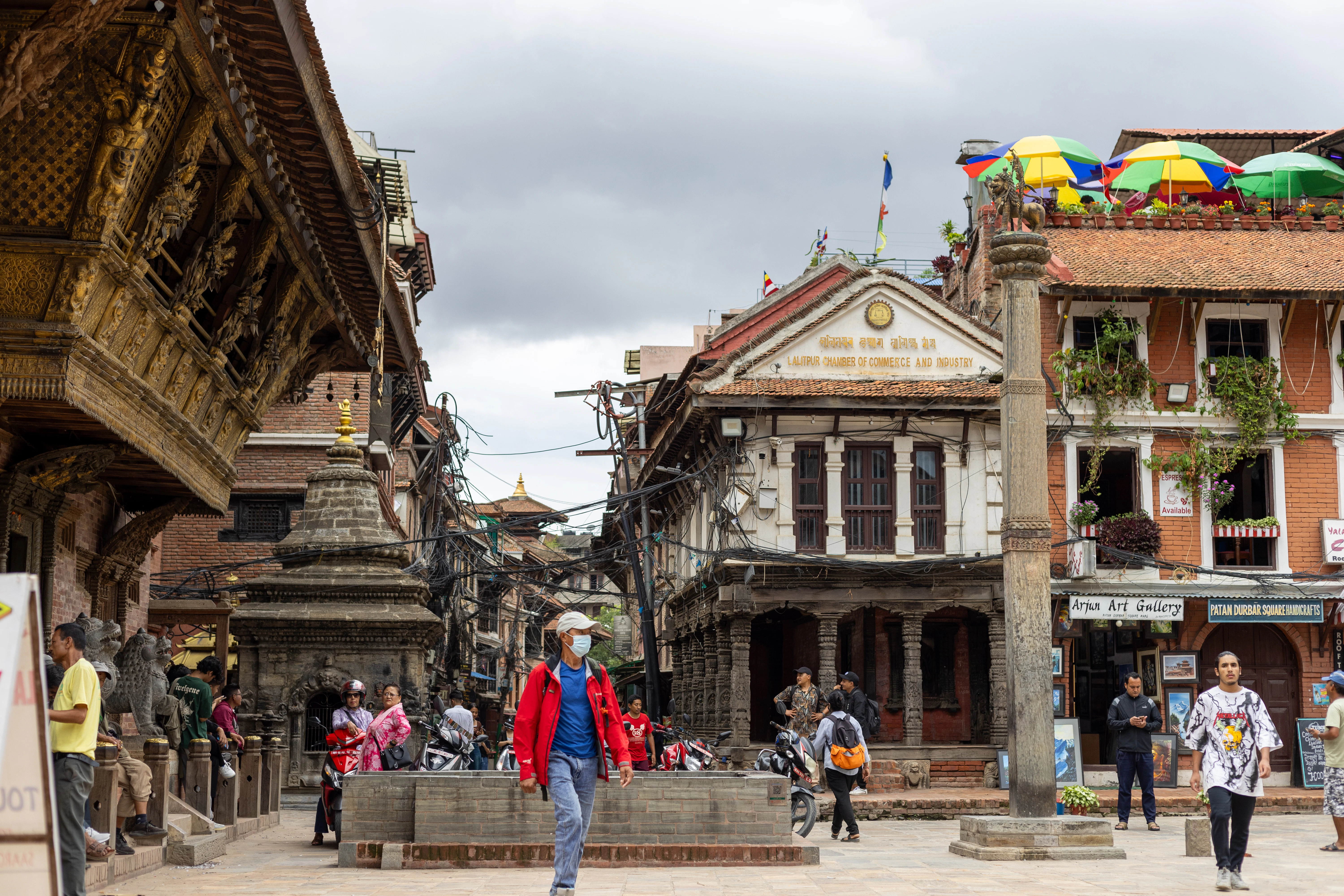 People walking in a historic town square with ornate buildings.
