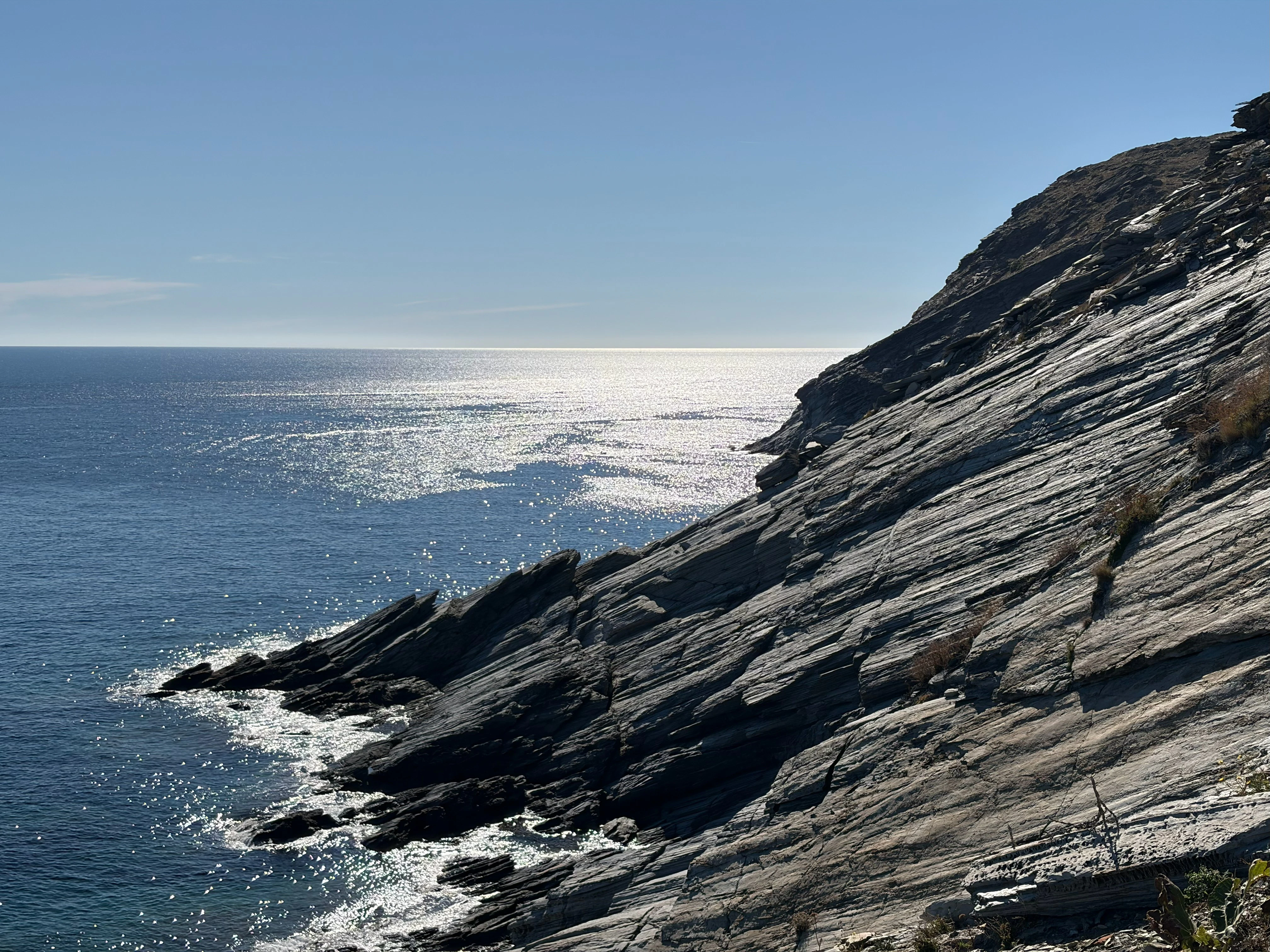Rocky coastline with sparkling ocean waves under a clear sky