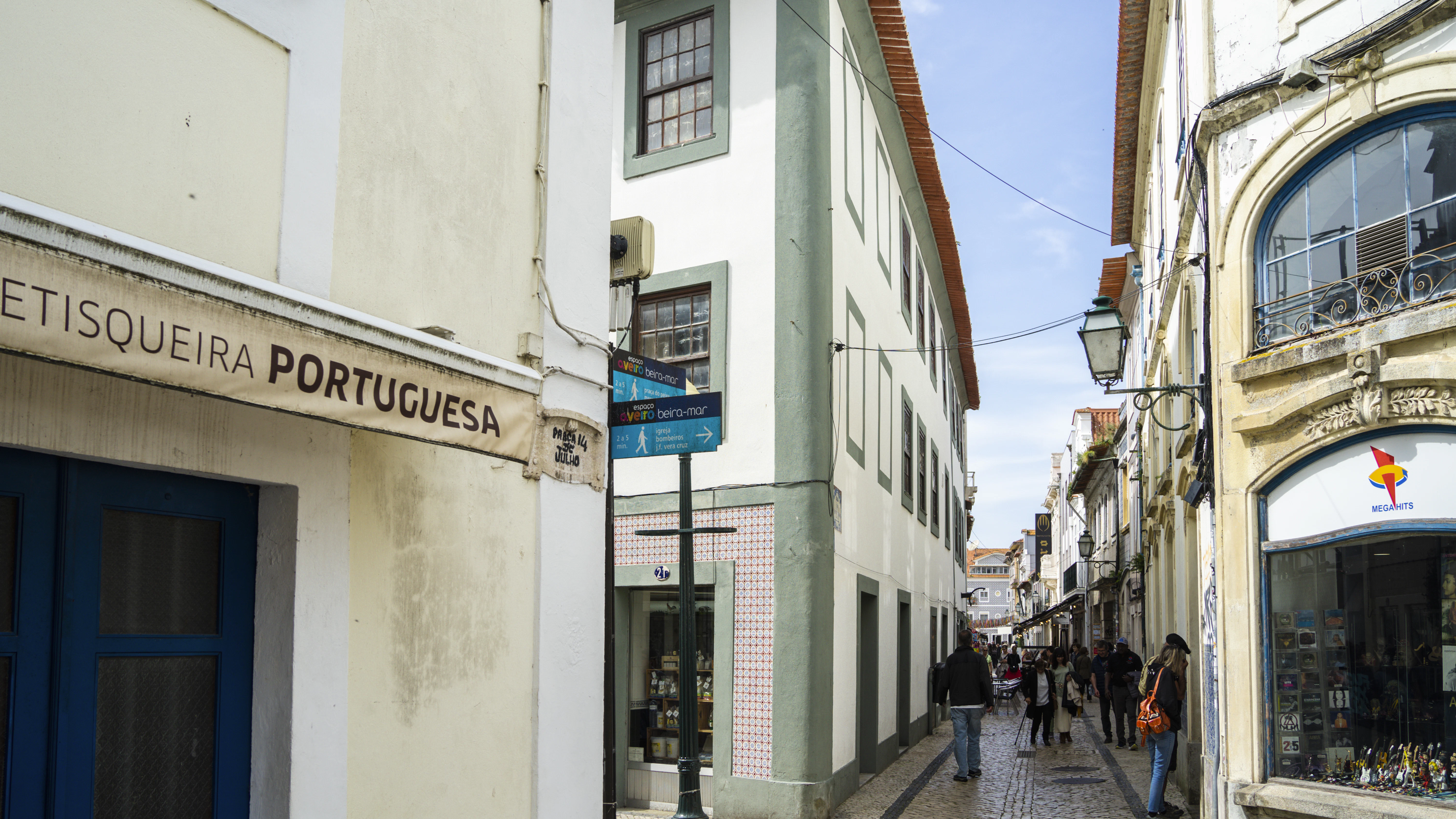a narrow street with people walking down it