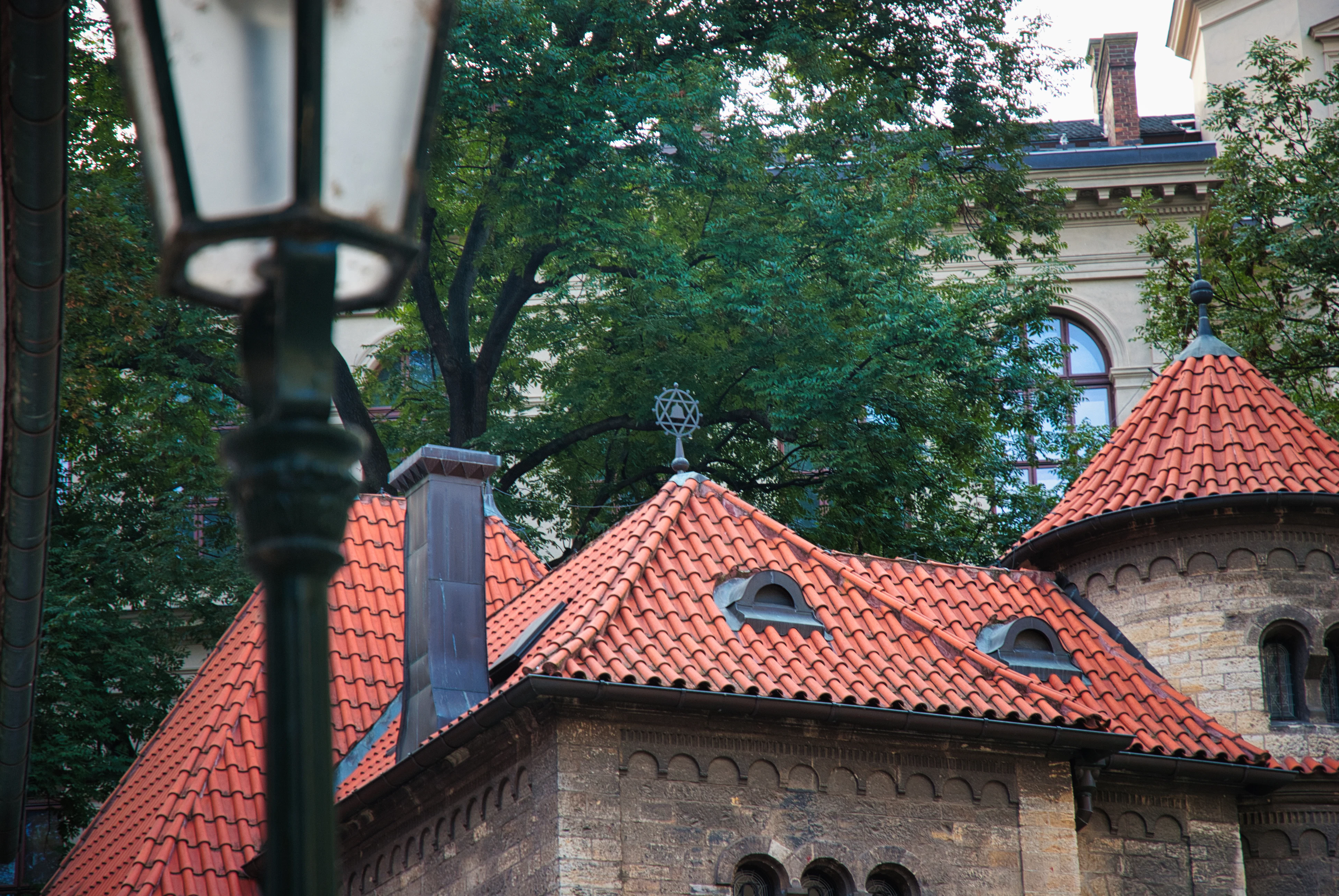 Old european building with red tiled roofs and lamp post.