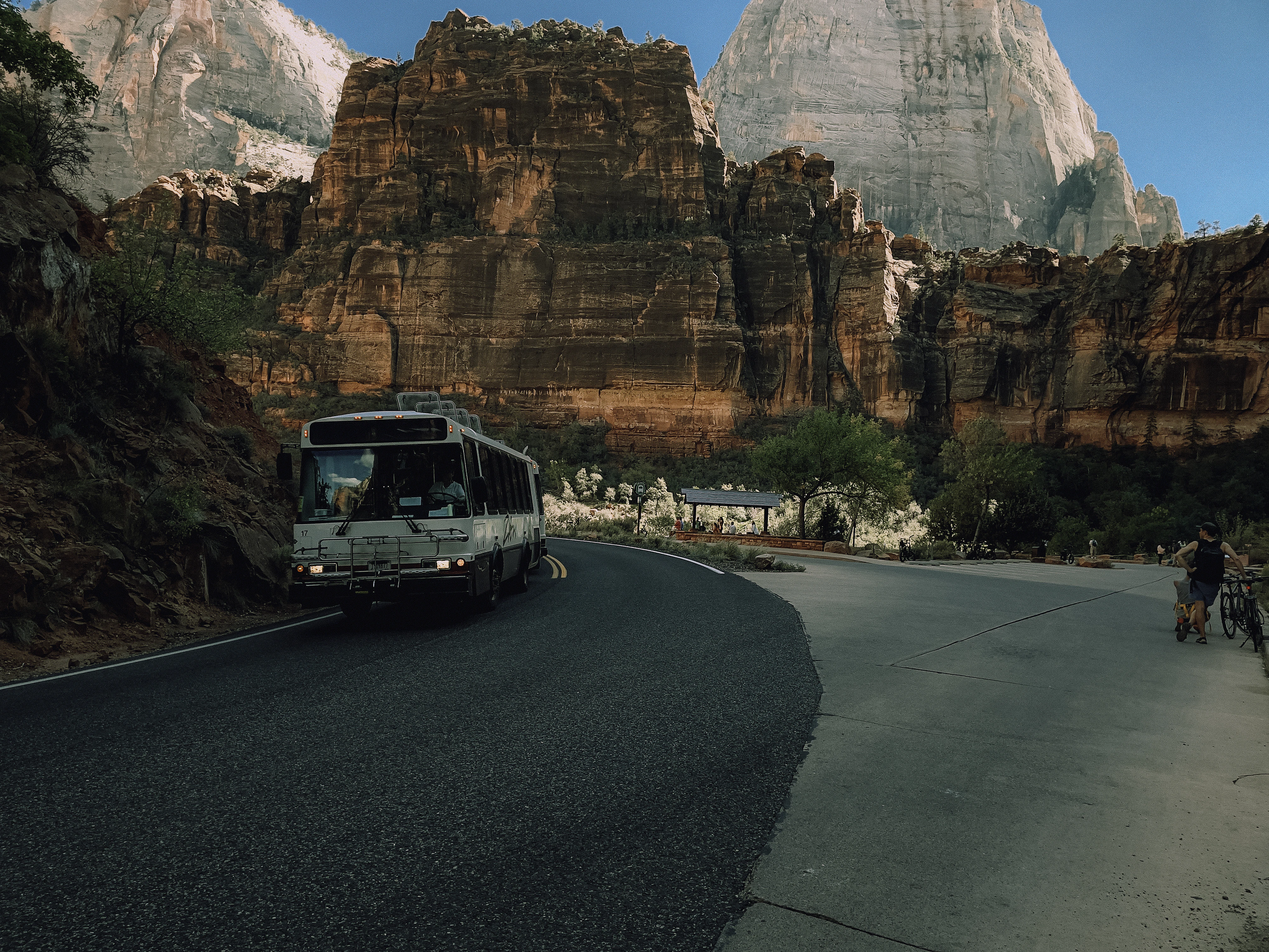 A bus driving down a road next to mountains