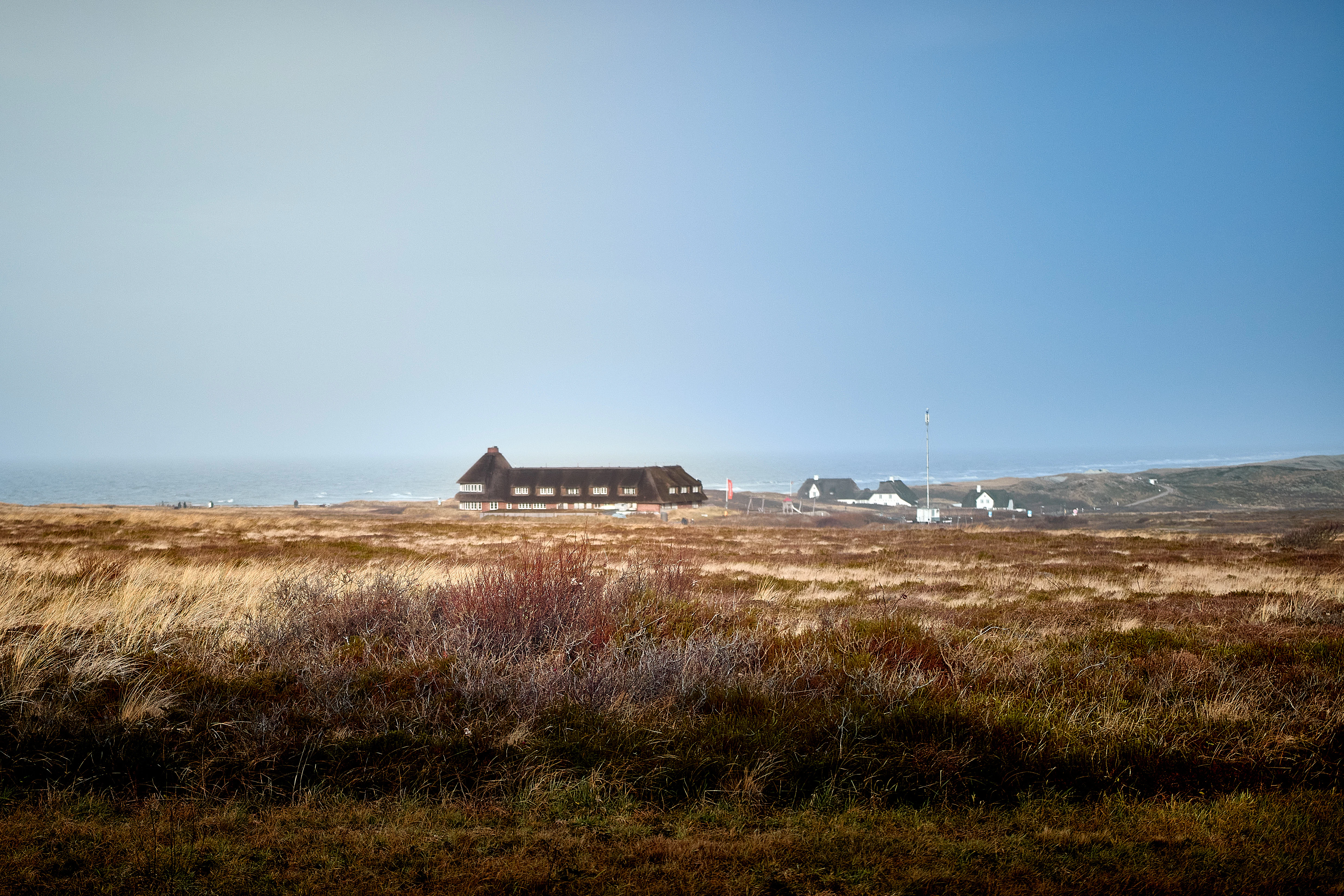 Long wooden building in a vast, dry landscape.