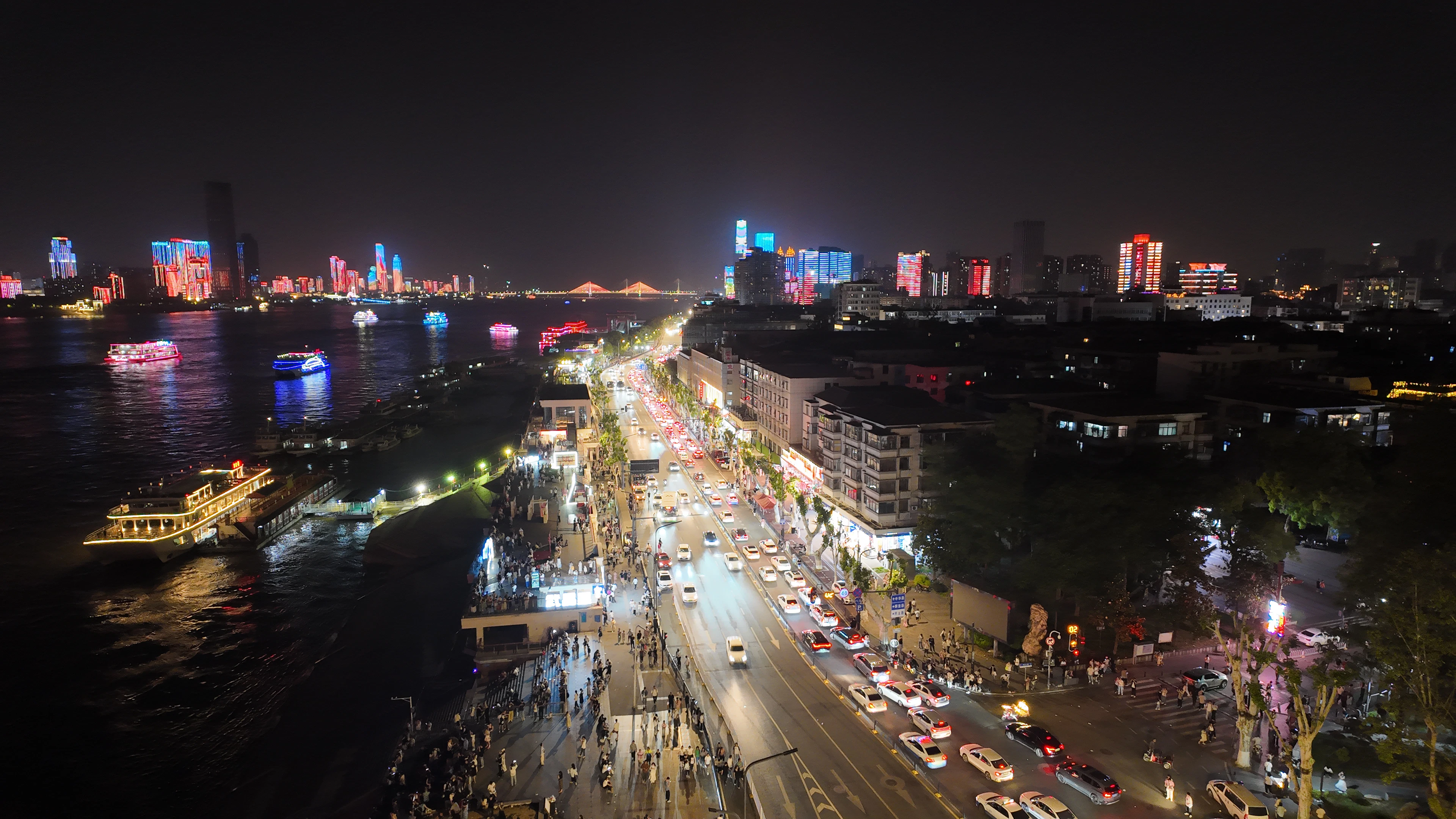 Busy city street and river at night