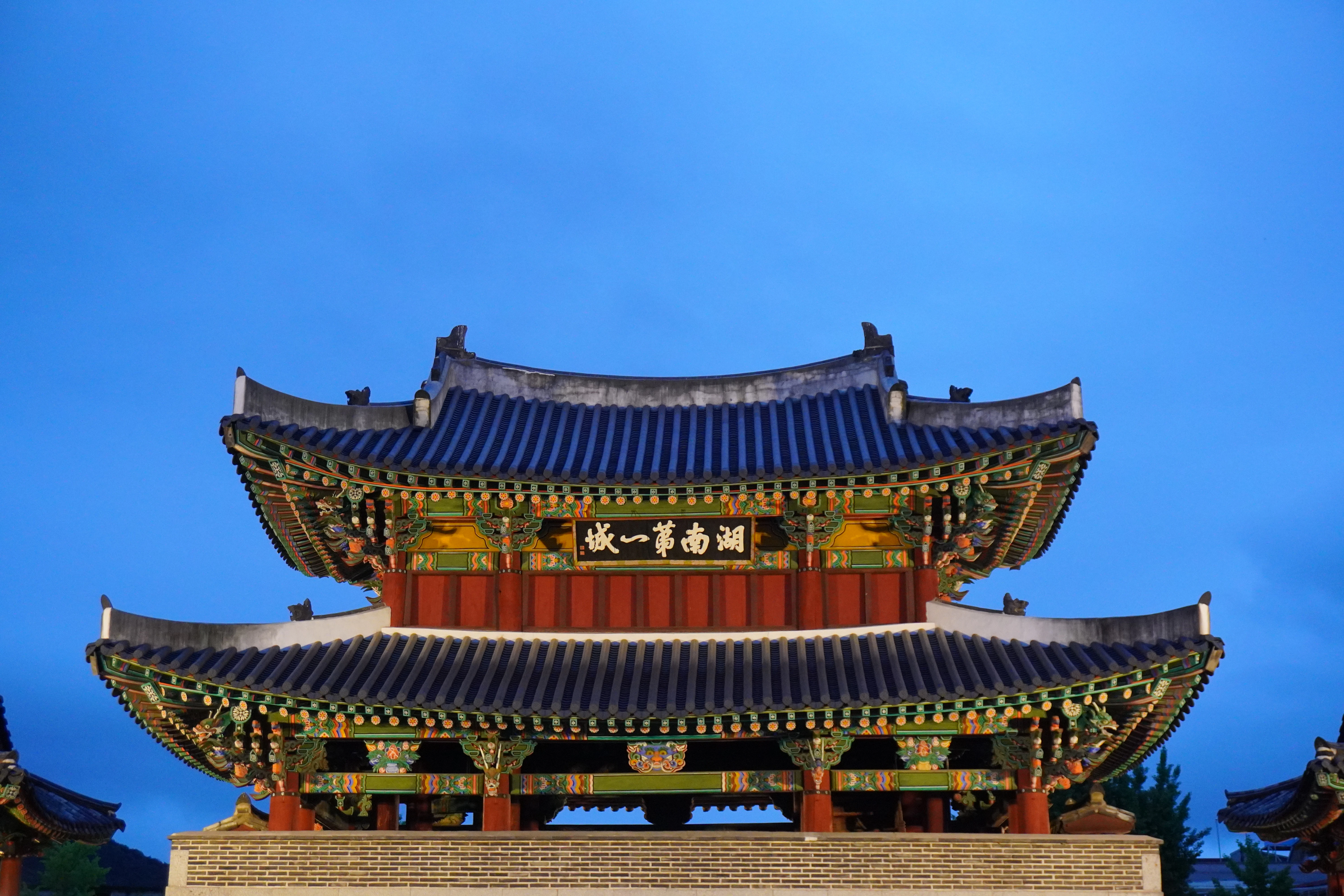 A traditional korean gate against a clear blue sky.