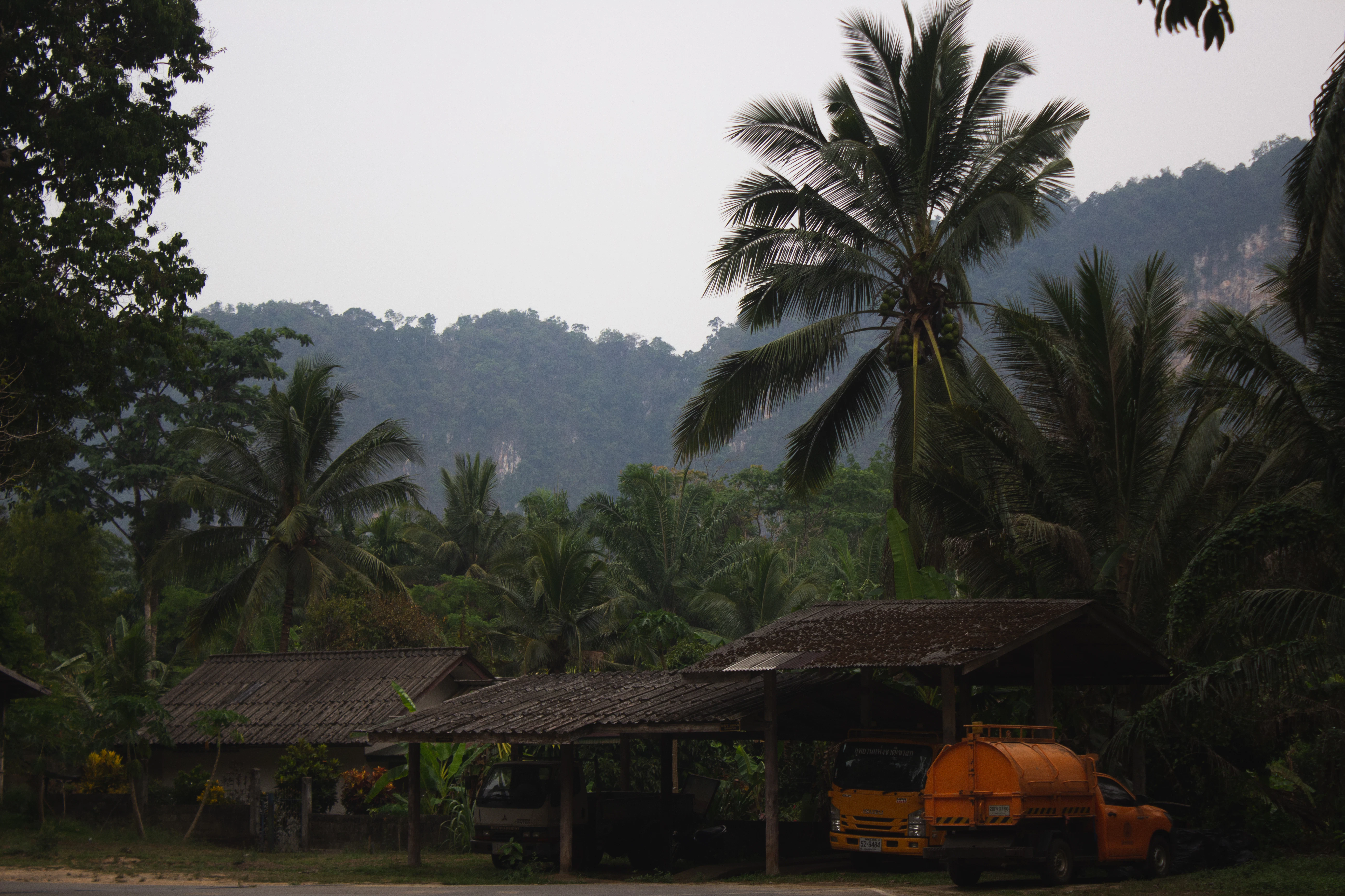 a yellow truck parked in front of a hut