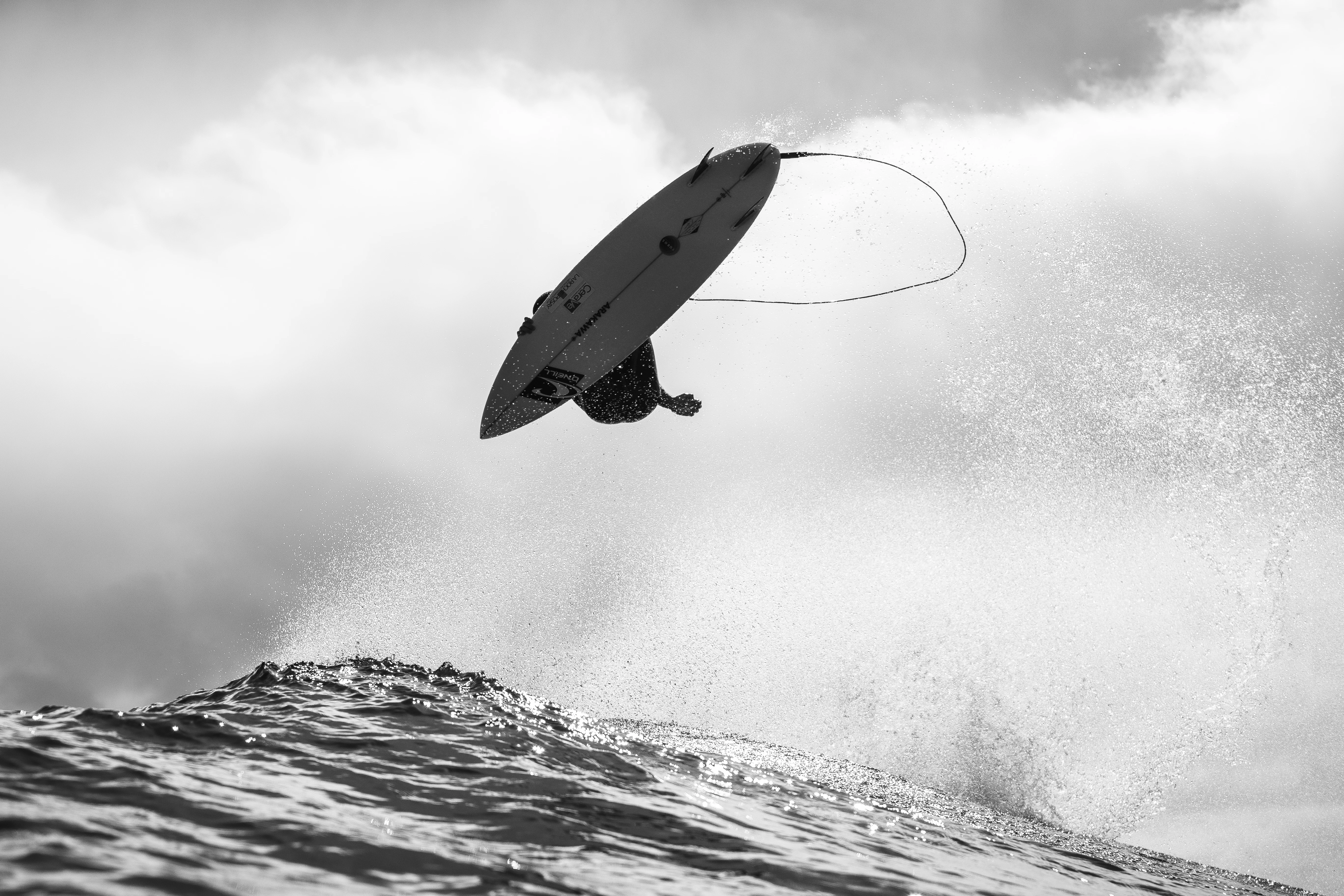 Surfer catches air over a breaking wave