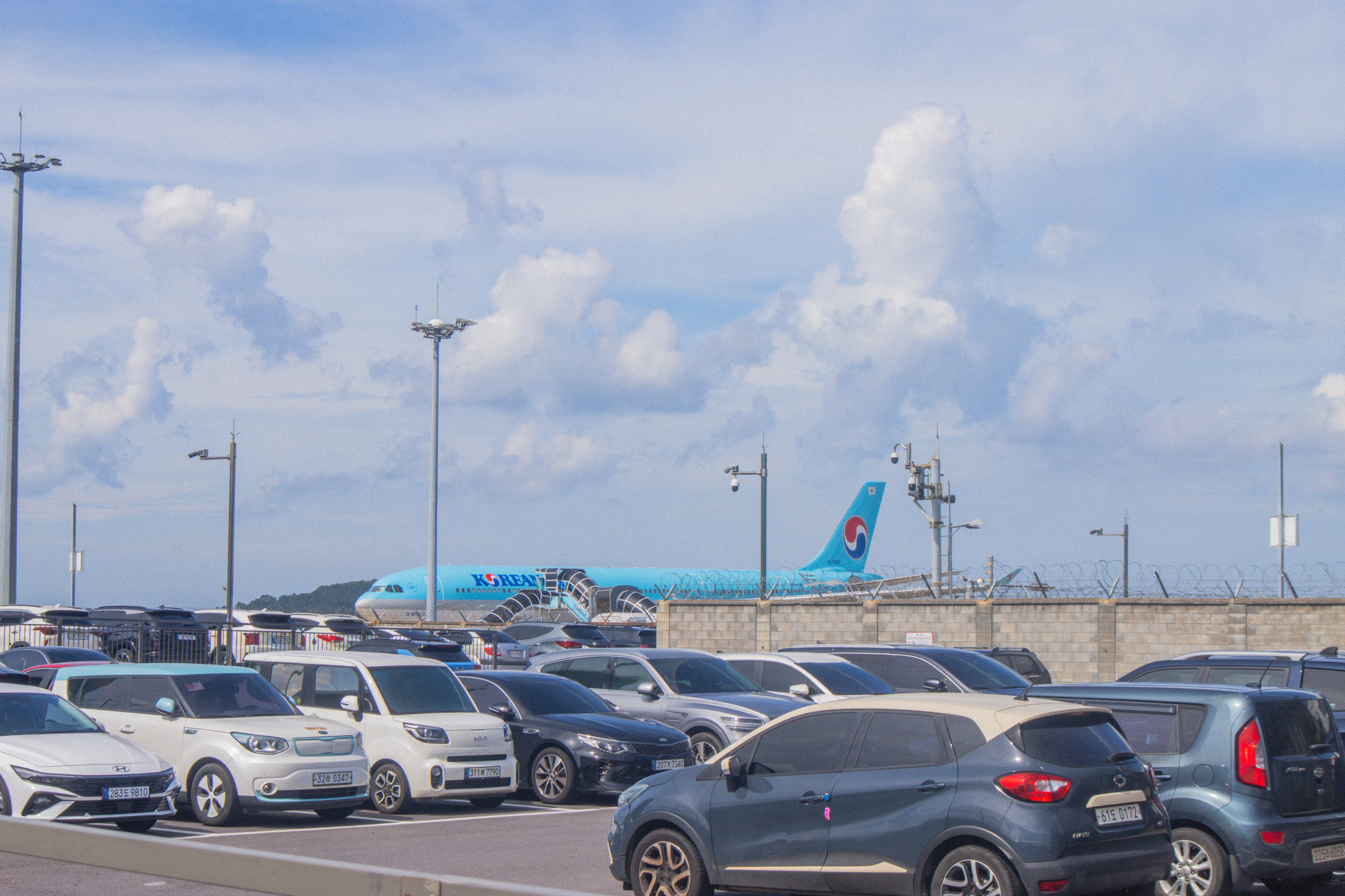 Cars parked with airplane in background