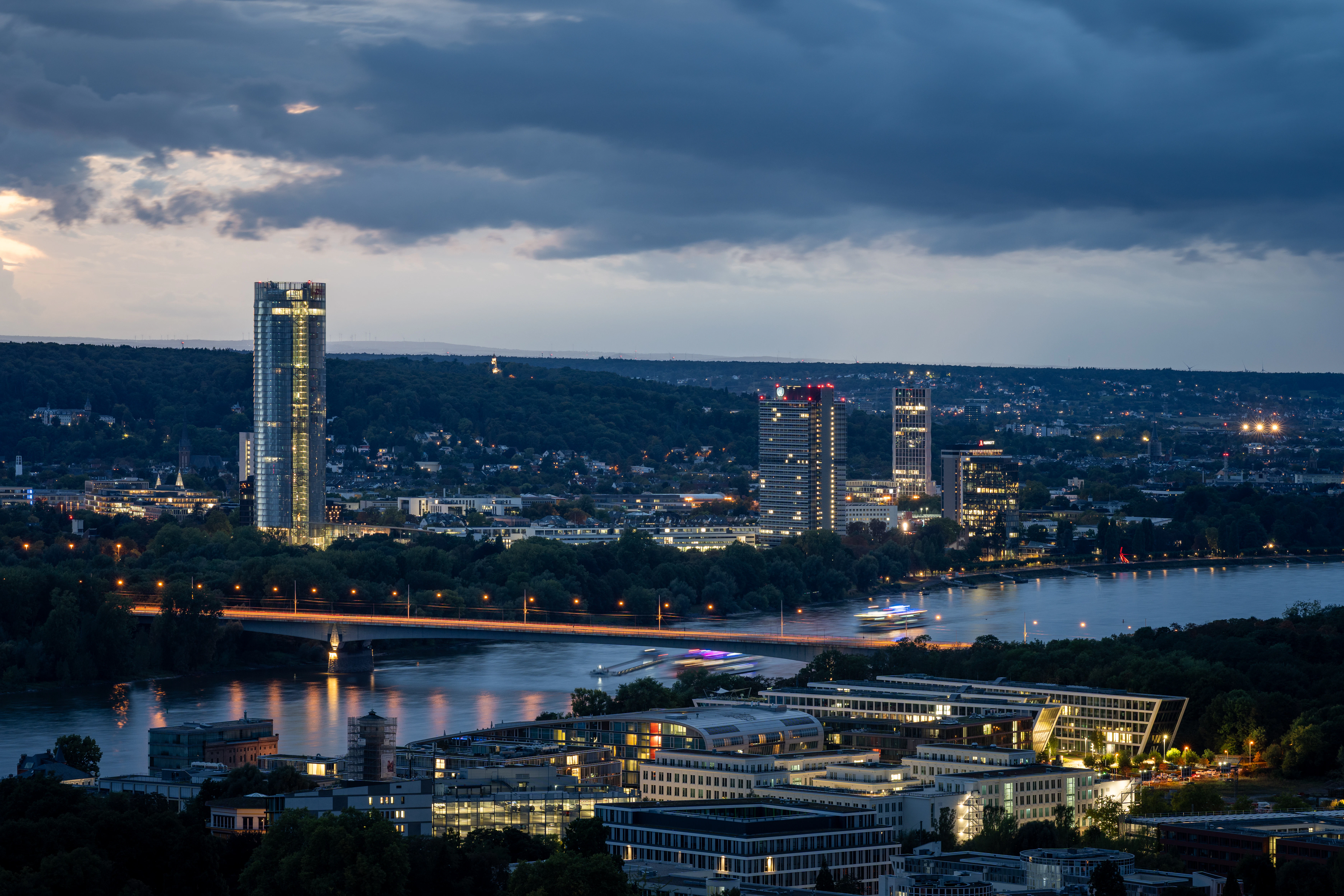 City skyline with river and bridge at dusk.