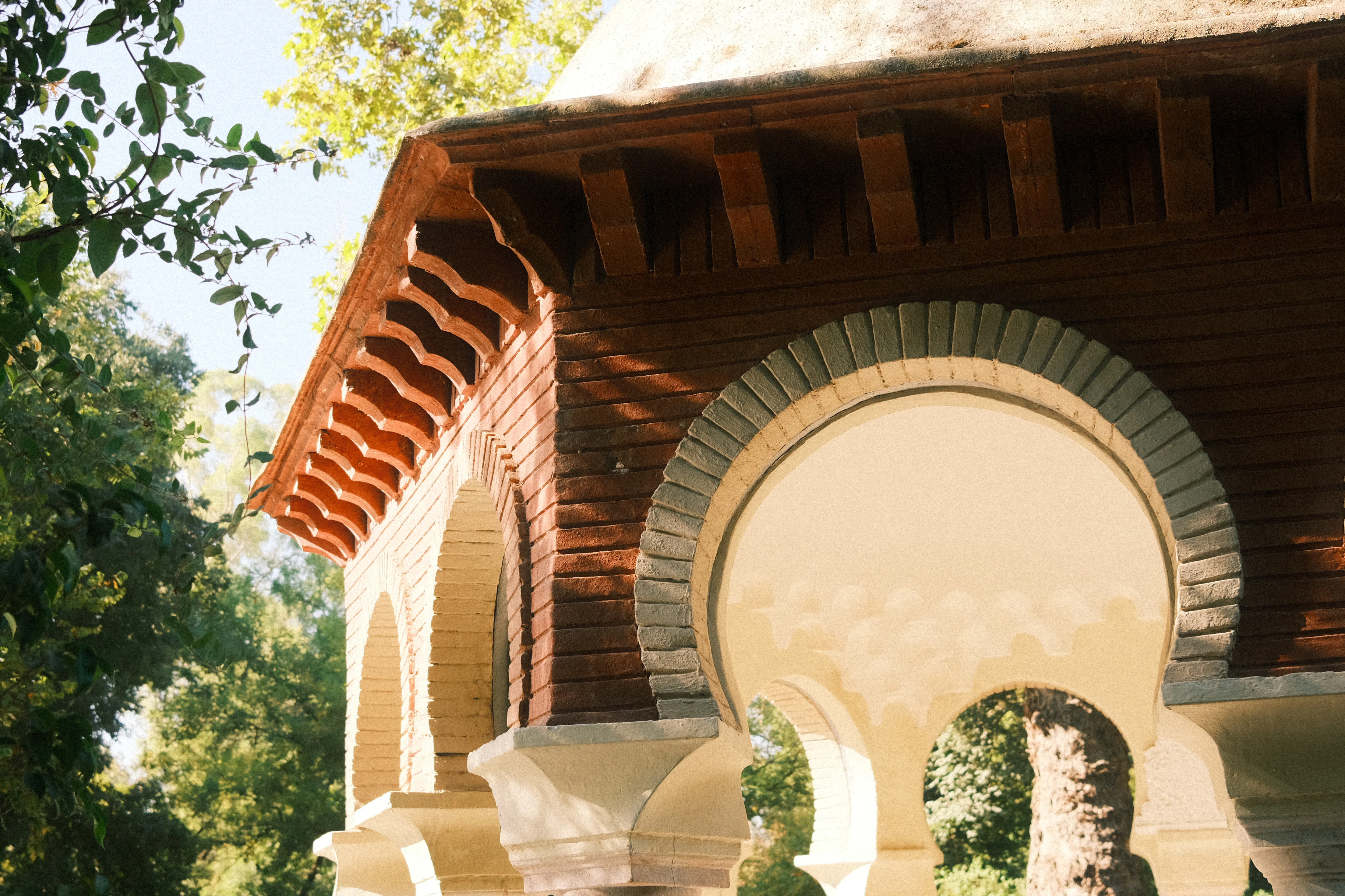 A gazebo in the middle of a park with trees in the background