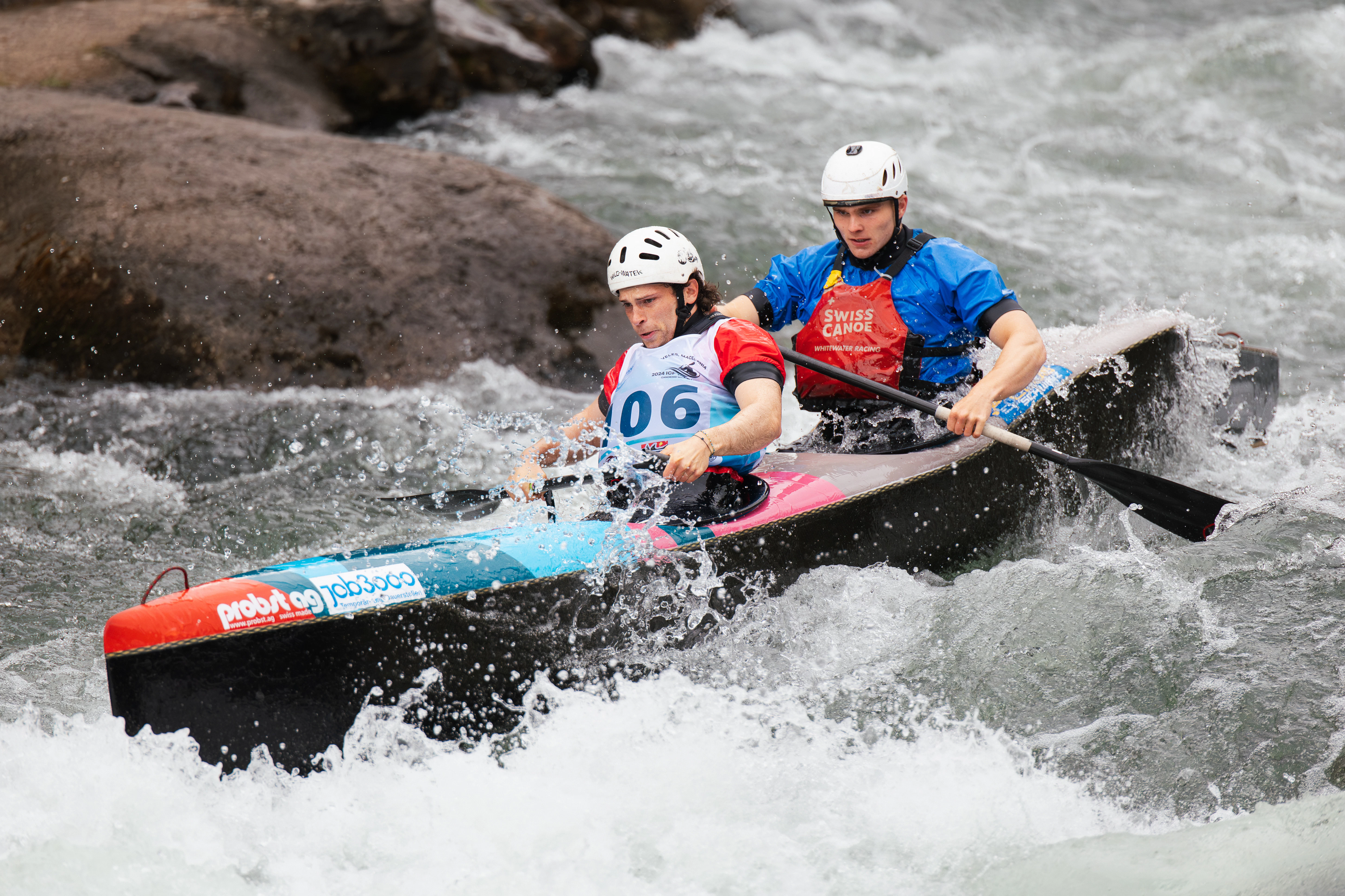 Two people in a canoe navigating whitewater rapids