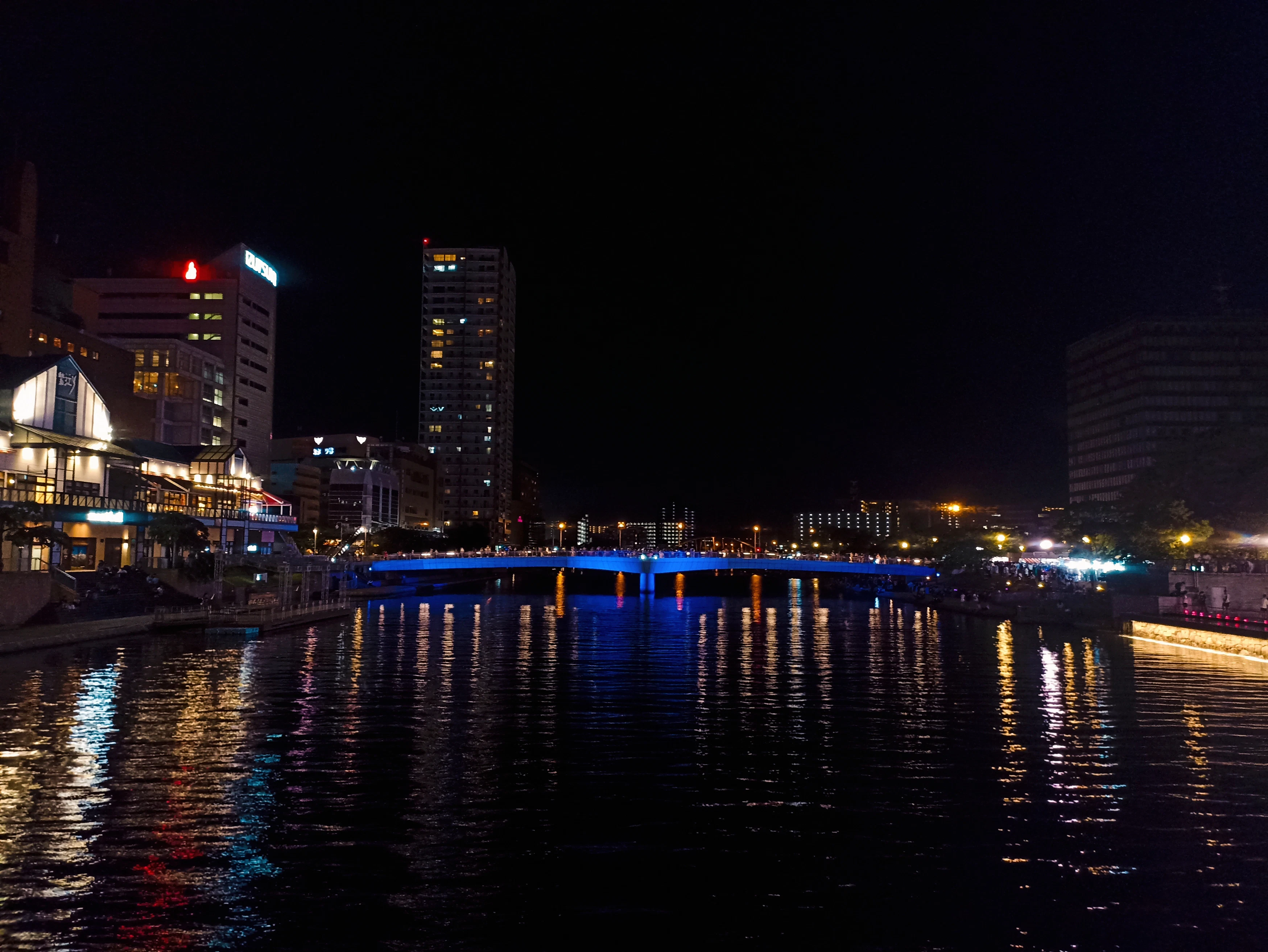 a city at night with lights reflecting in the water