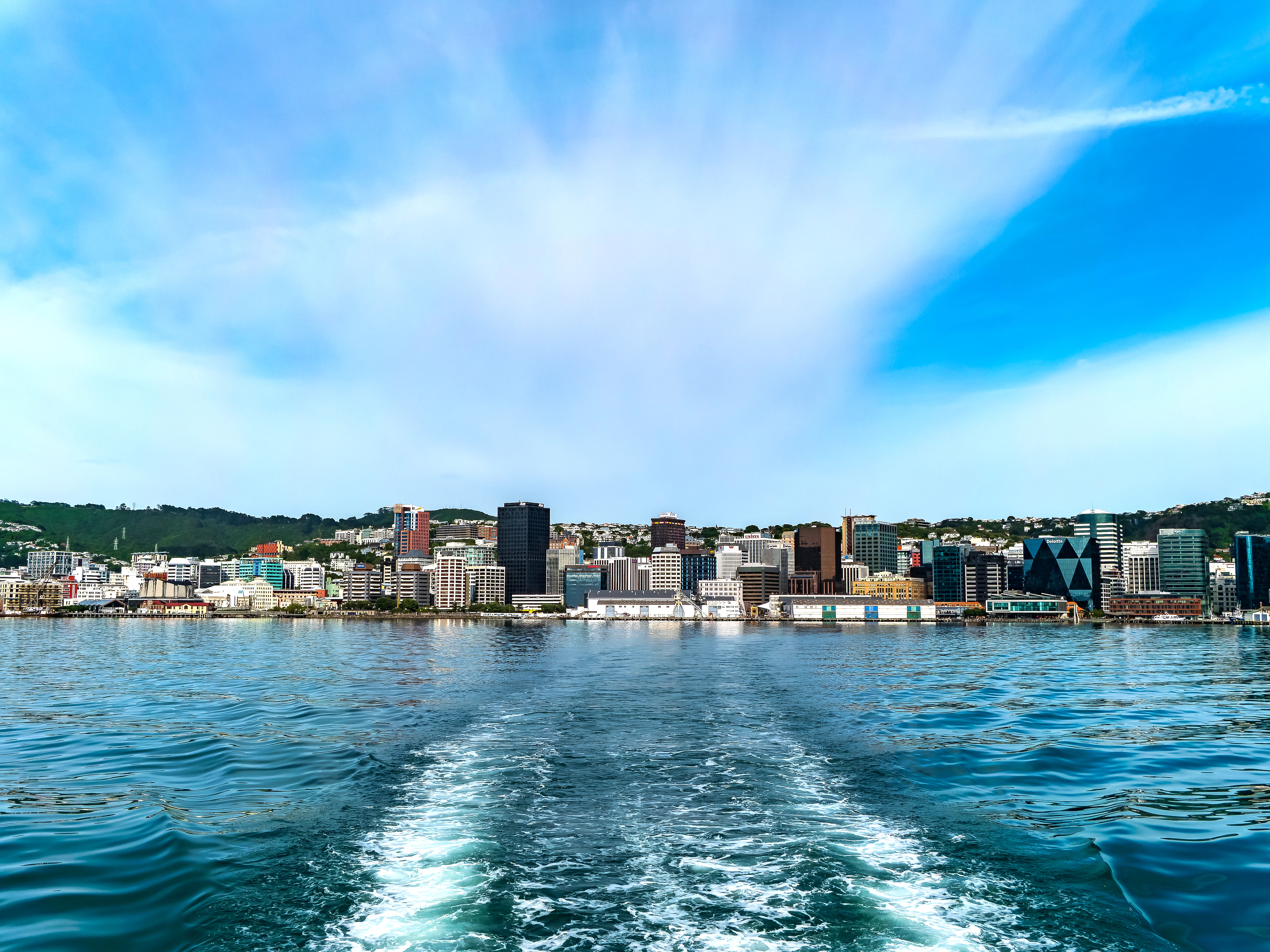 City skyline viewed from the water with wake.